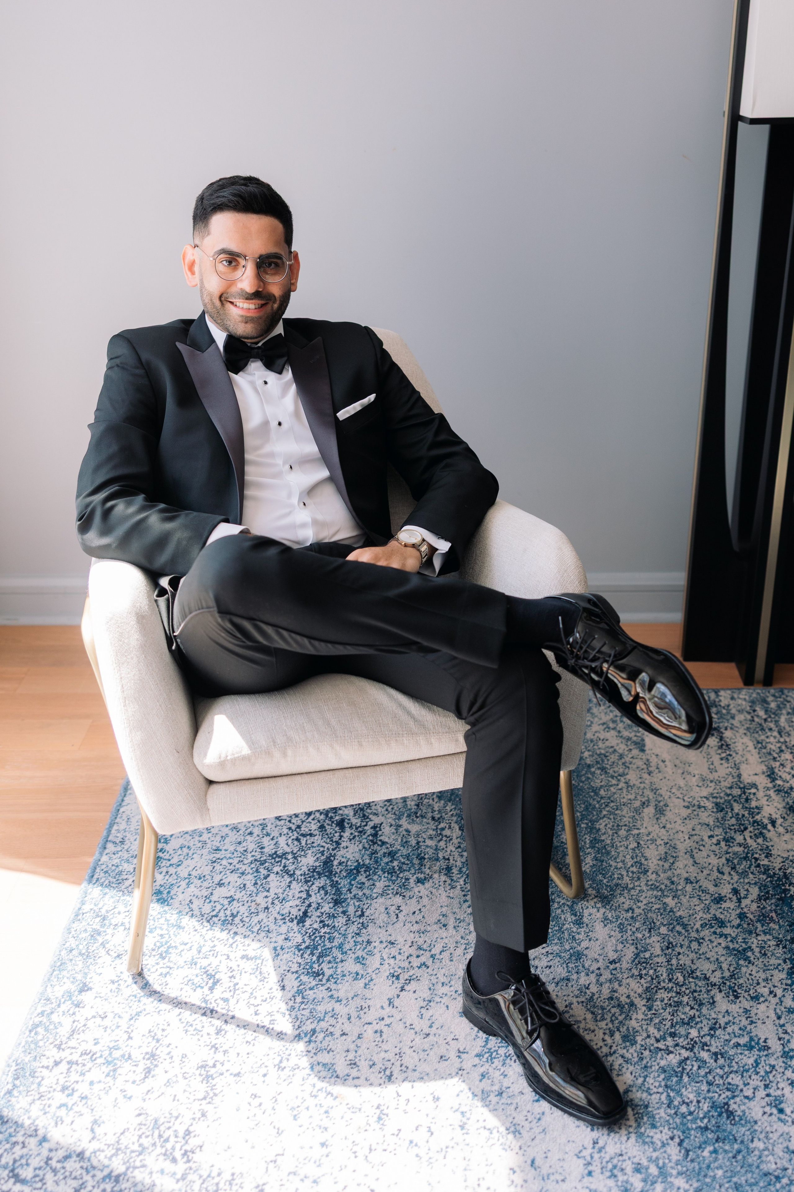 Groom seated on a bed in a modern hotel room