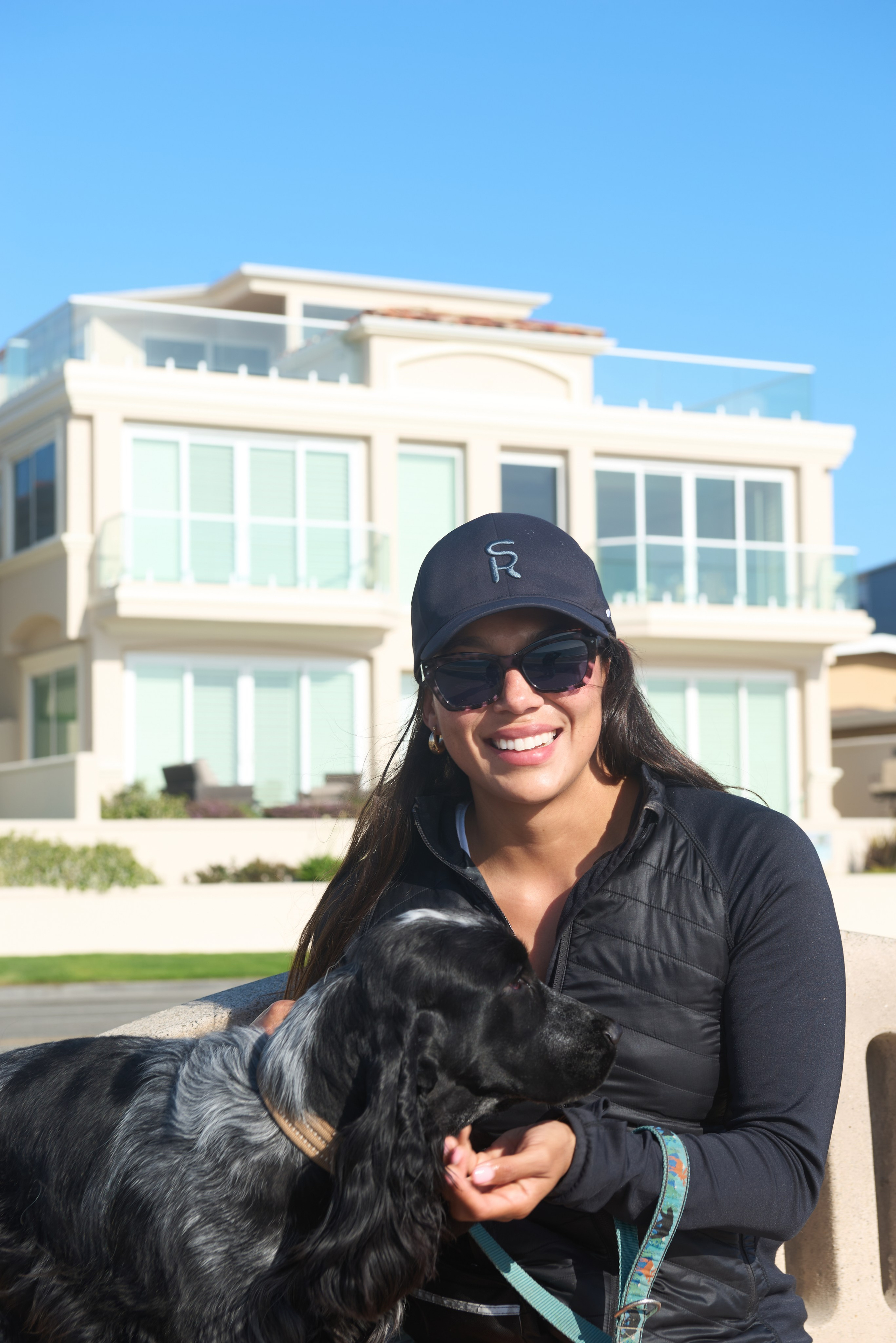 Black lab sitting beside its owner during an outdoor lifestyle photography session in South Bay Los Angeles