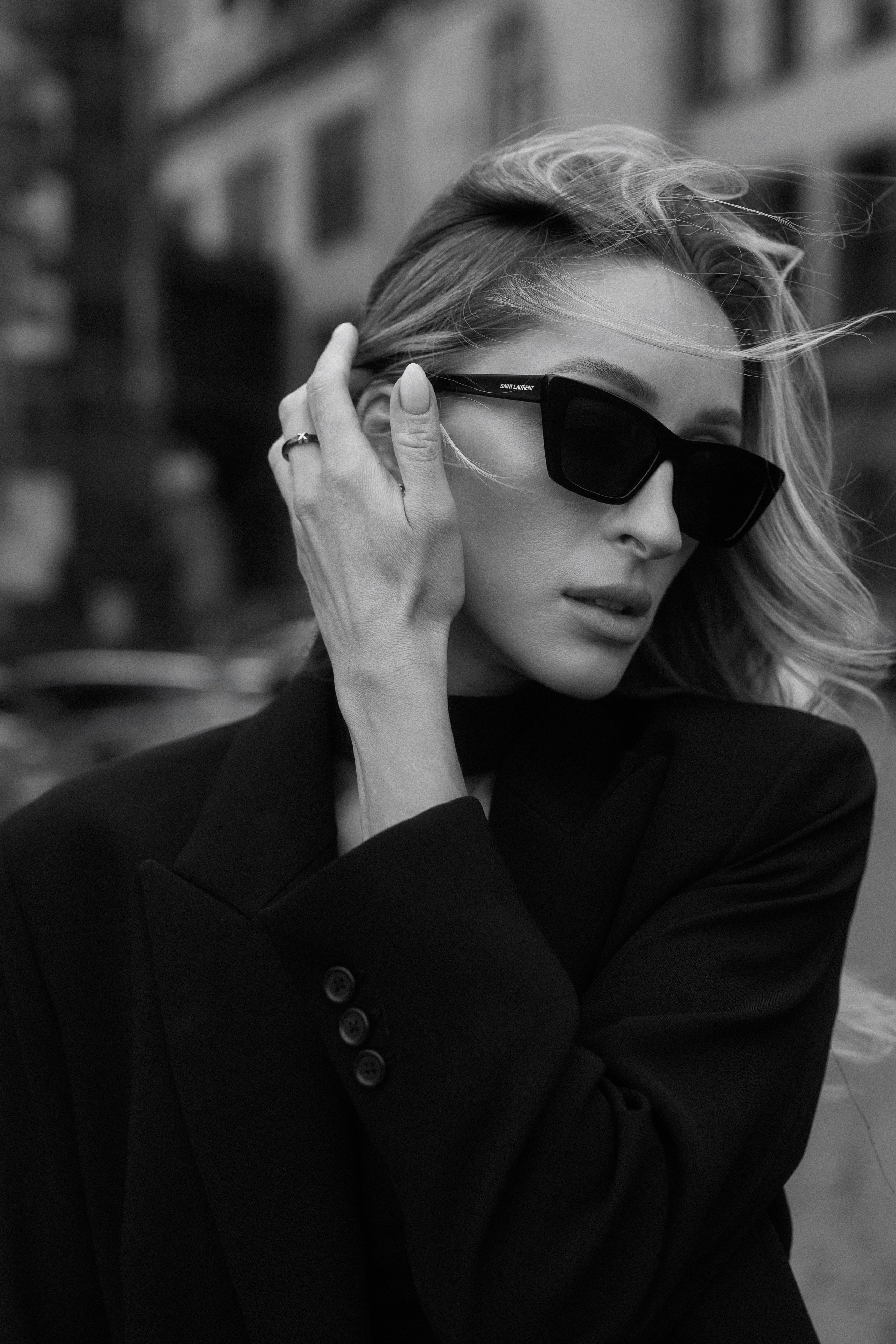 Close-up black and white portrait of a stylish woman wearing sunglasses and a black blazer in Dresden, Germany. Timeless female portrait and editorial photography by a photographer serving Leipzig and Wurzen. Крупный чёрно-белый портрет стильной девушки в солнцезащитных очках и чёрном жакете в Дрездене, Германия. Вневременная женская и редакционная фотография от фотографа, работающего в Лейпциге и Вурцене.