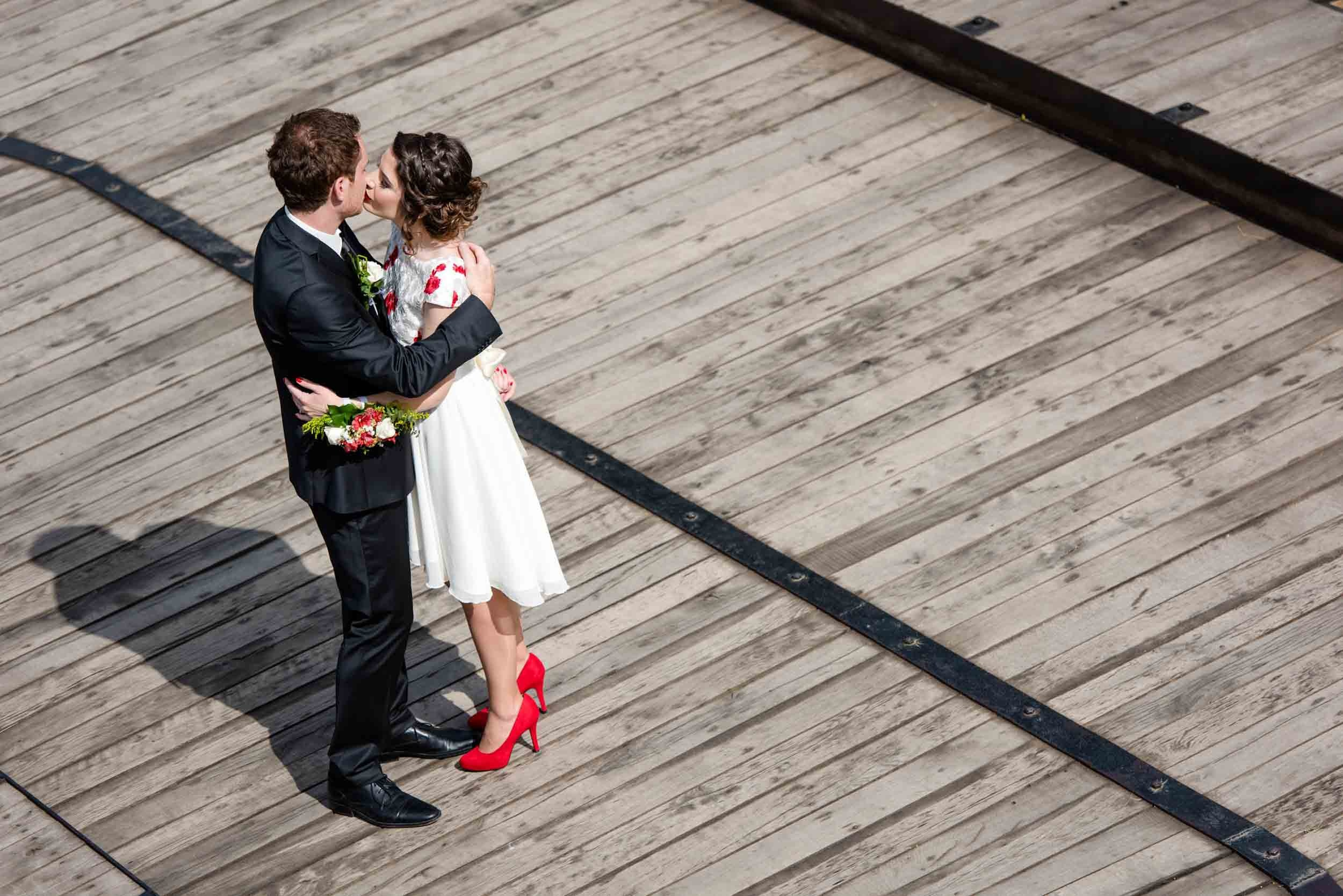 Romantični ples mladenaca na drvenom mostu Petrovaradinske tvrđave – emotivna Fotografija mladenaca iz ptičije perspektive.