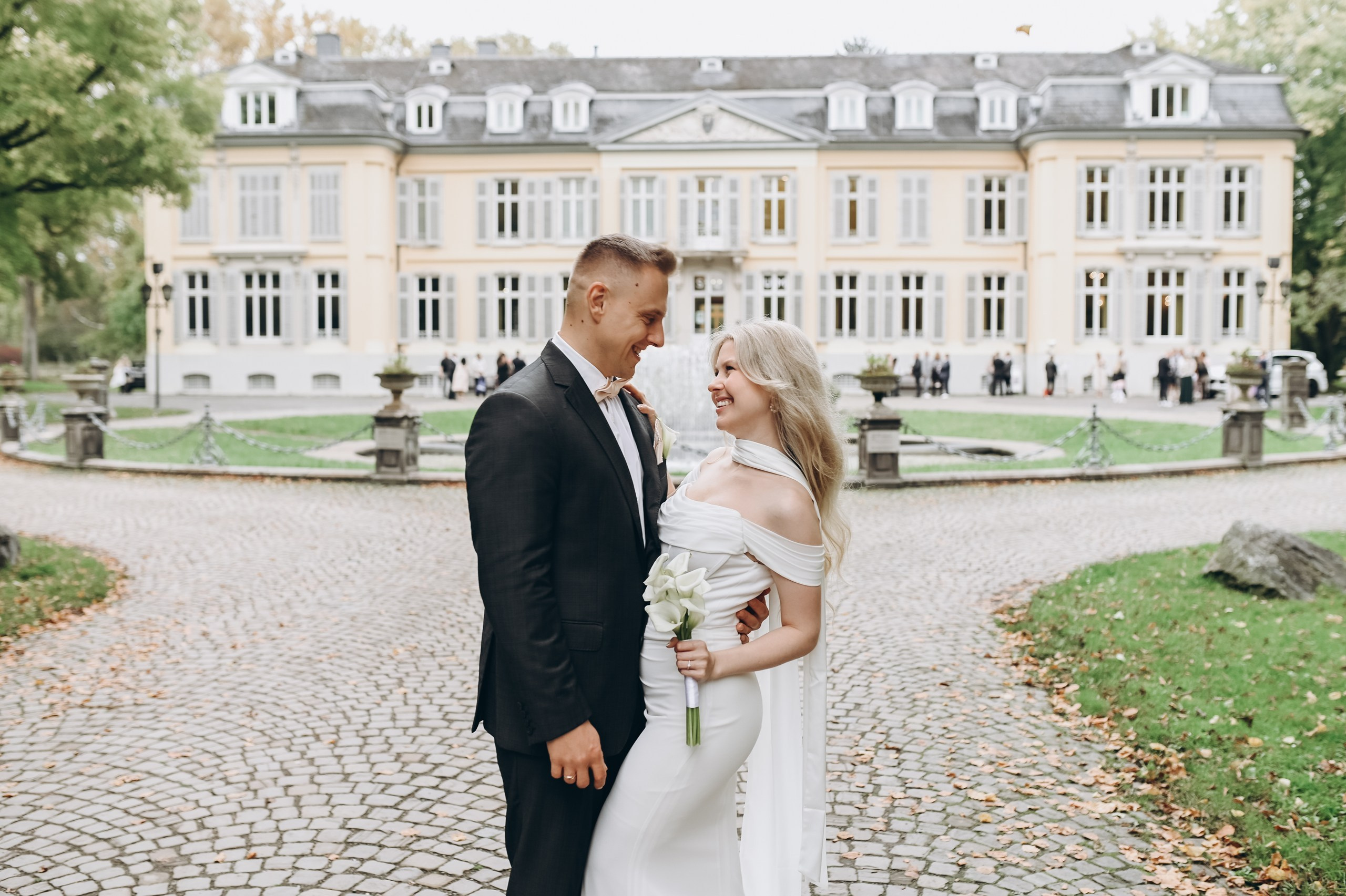 Glückliches Brautpaar bei romantischem Spaziergang in der Nähe von Schloss Morsbroich in Leverkusen