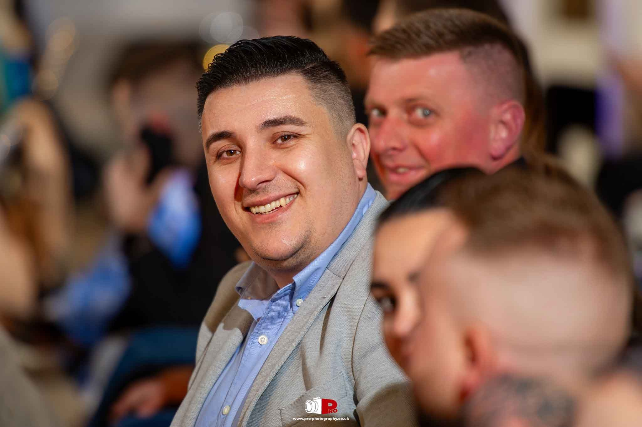 Close-up of a cheerful guest smiling at the camera during a gala event.