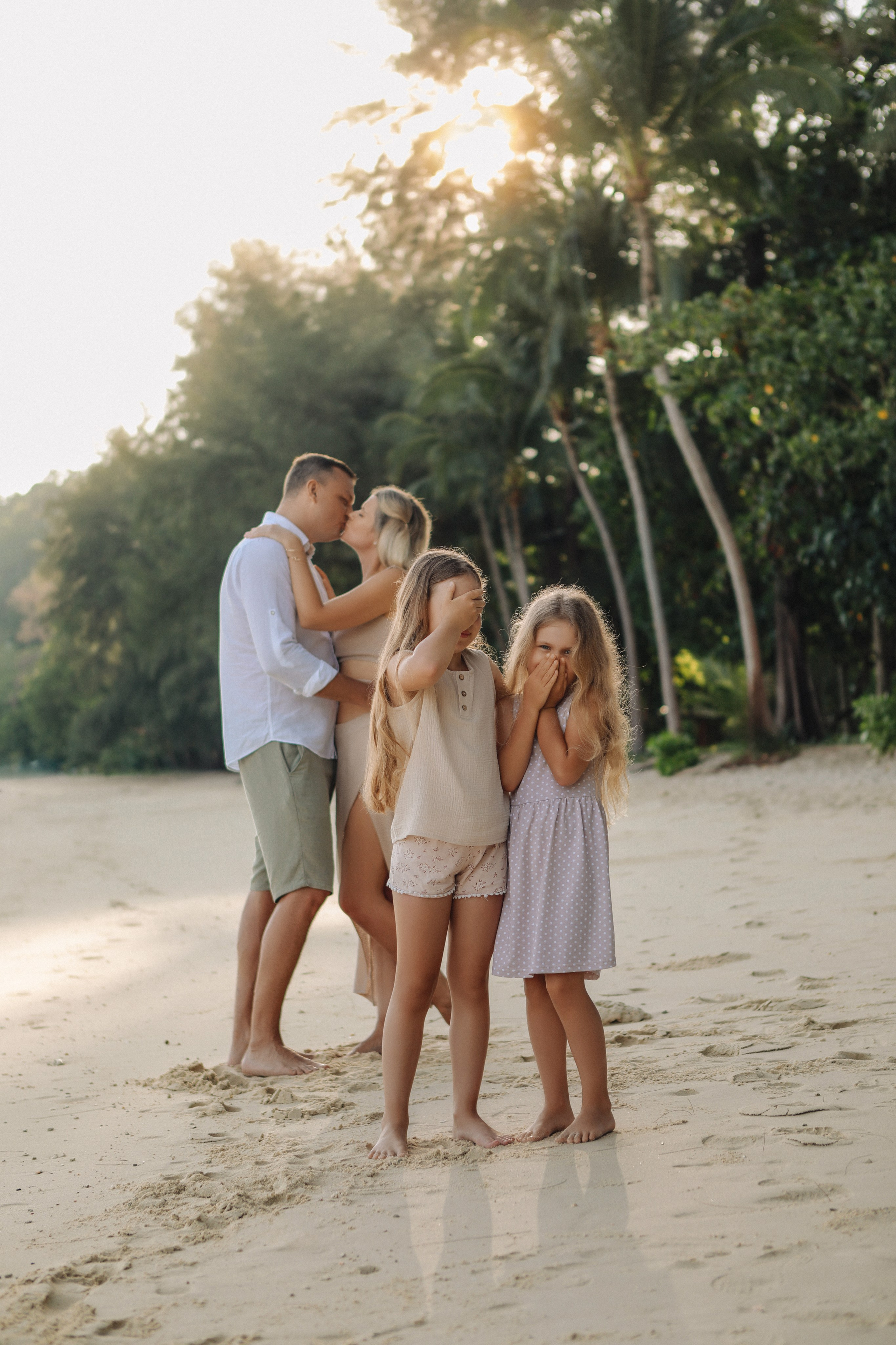 Счастливая семья в белых нарядах но фоне моря 