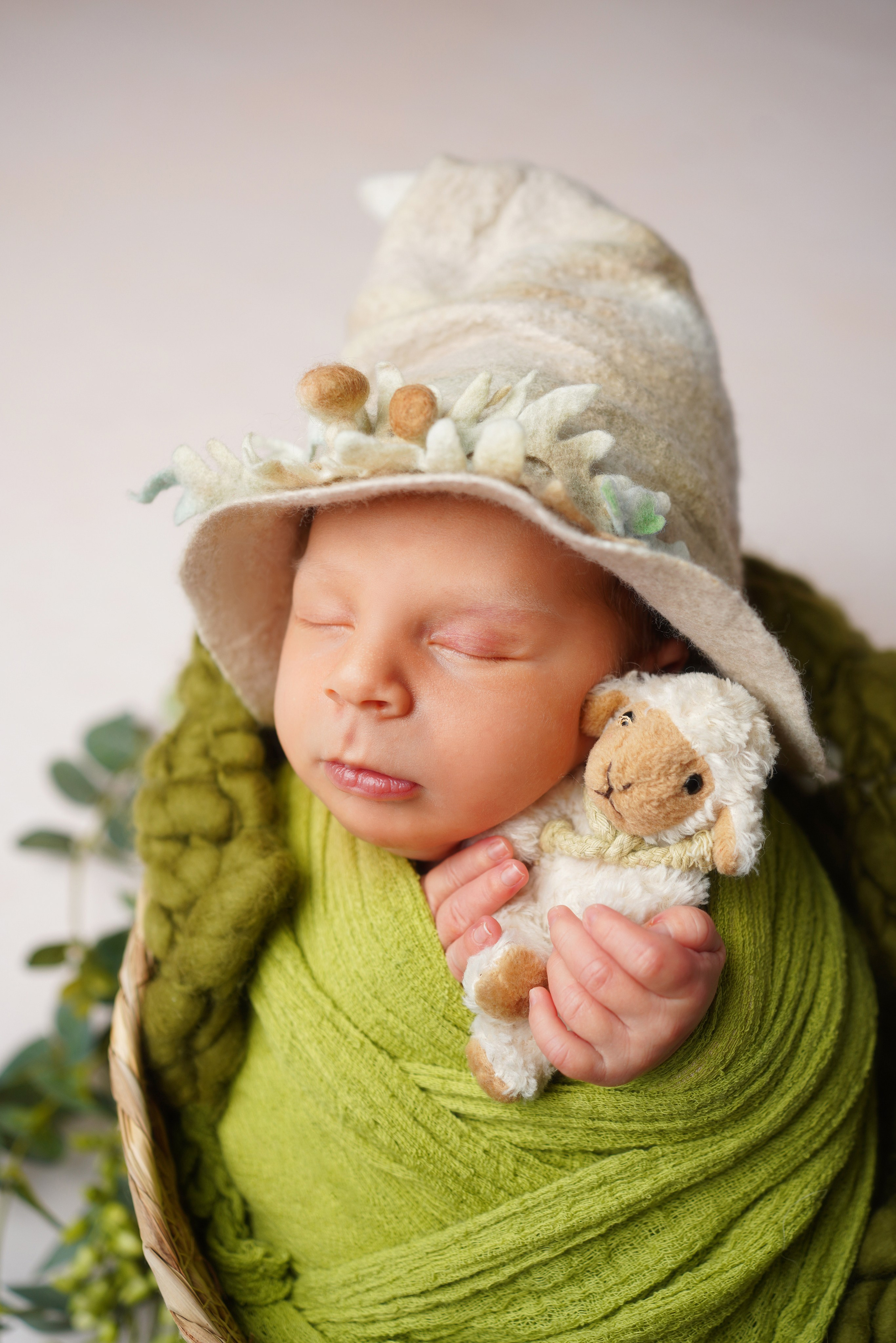 Baby mit Kuscheltier schläft friedlich in Decke gewickelt