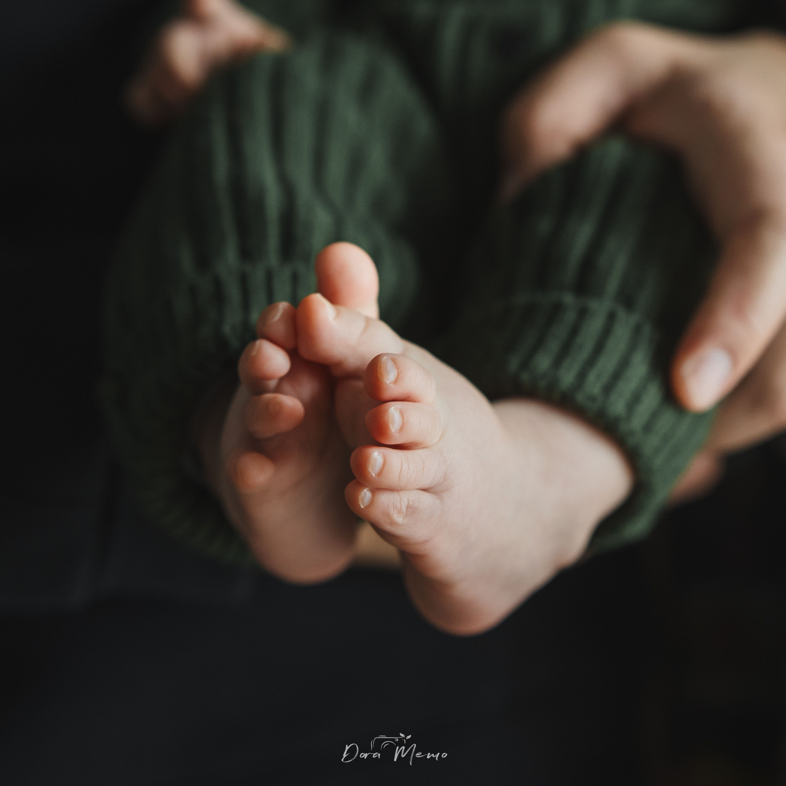 Close-up of baby feet in green knitted outfit, lifestyle newborn photography in Shanghai home