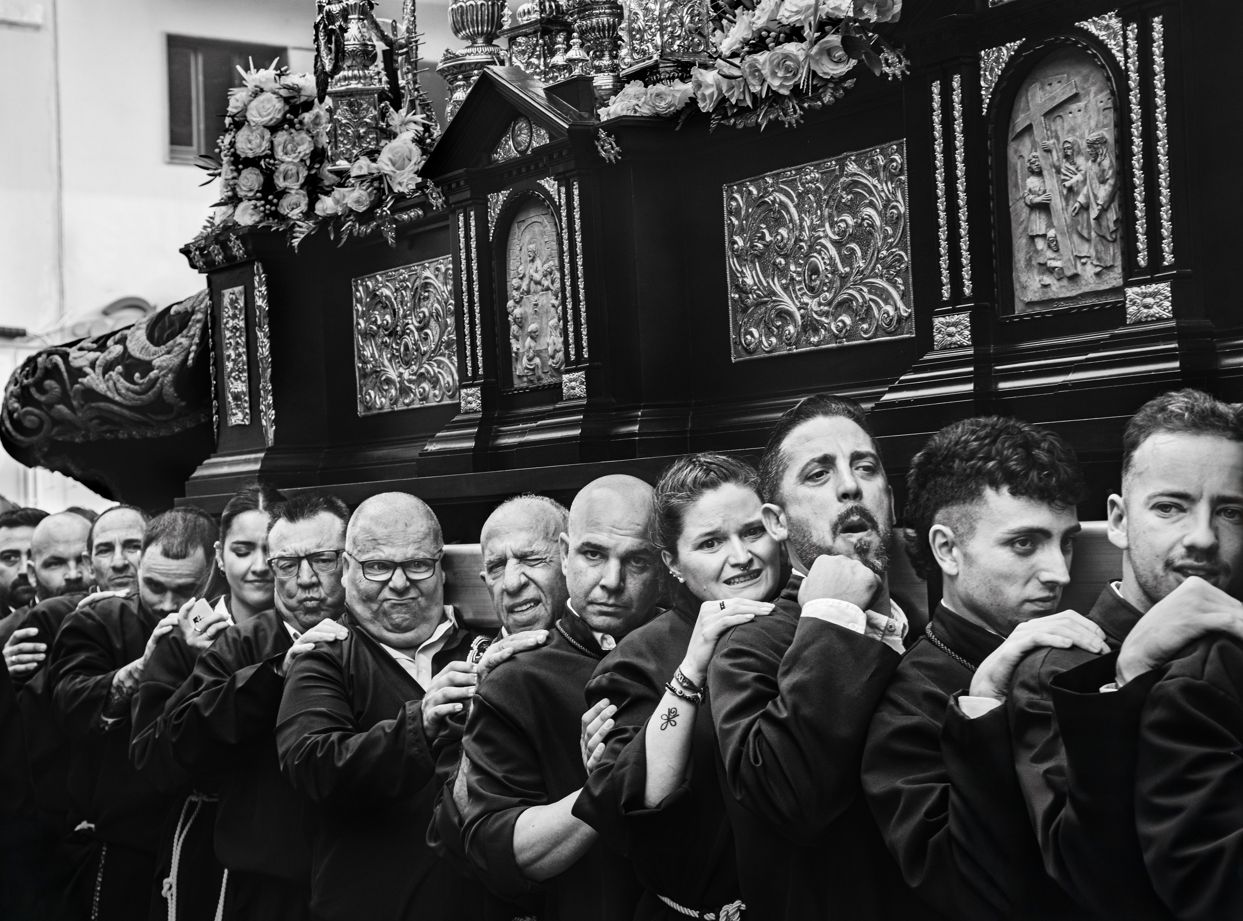 Men carrying religious paso float during Semana Santa Holy Week procession in Malaga, Spain