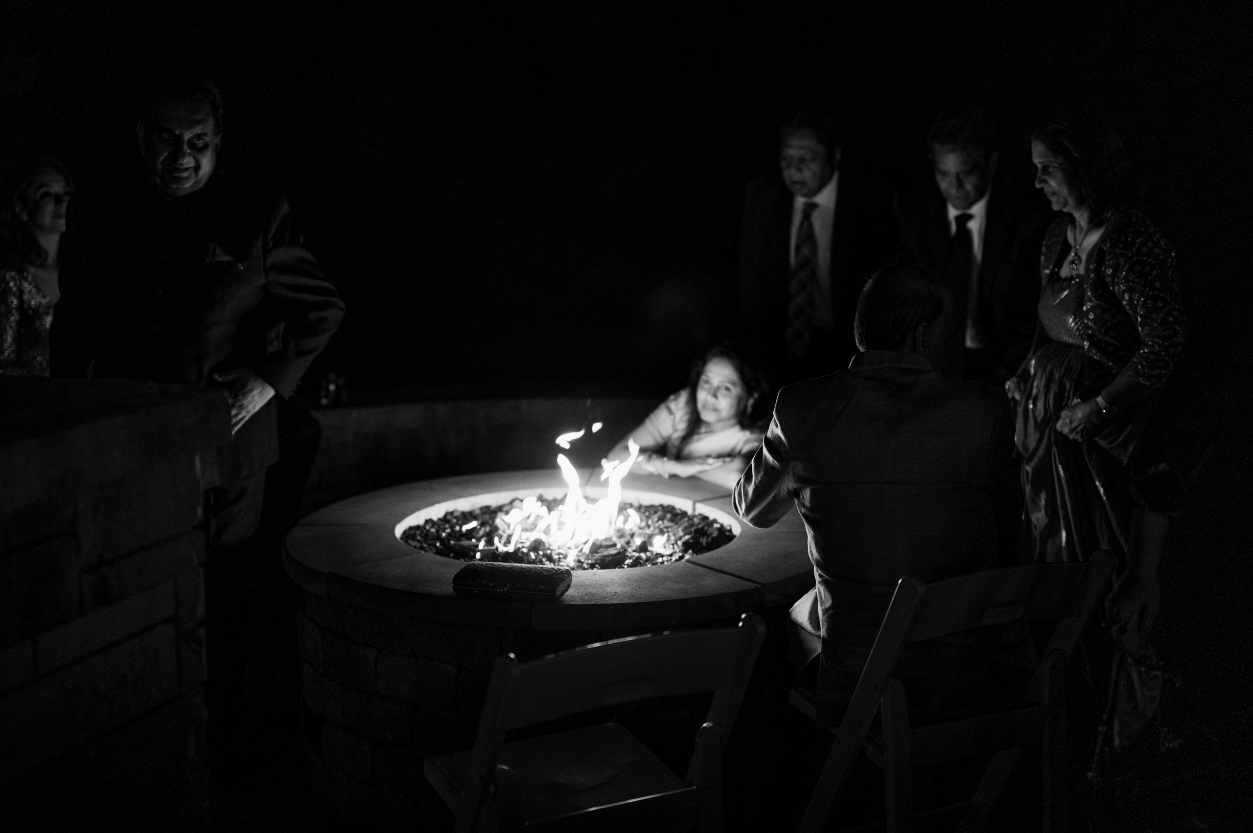 a group of people sitting around a fire pit