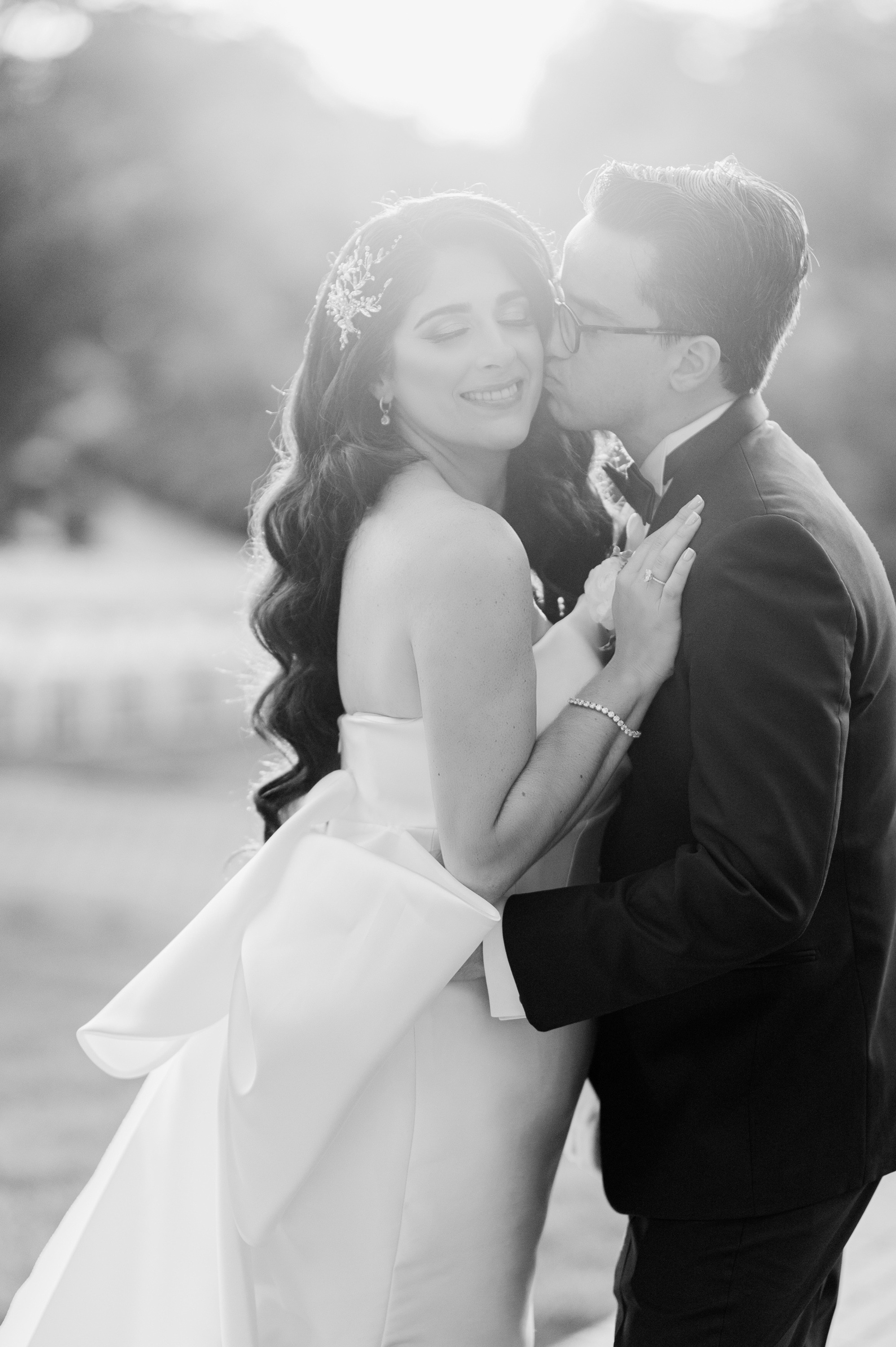 a bride and groom kissing in the sun