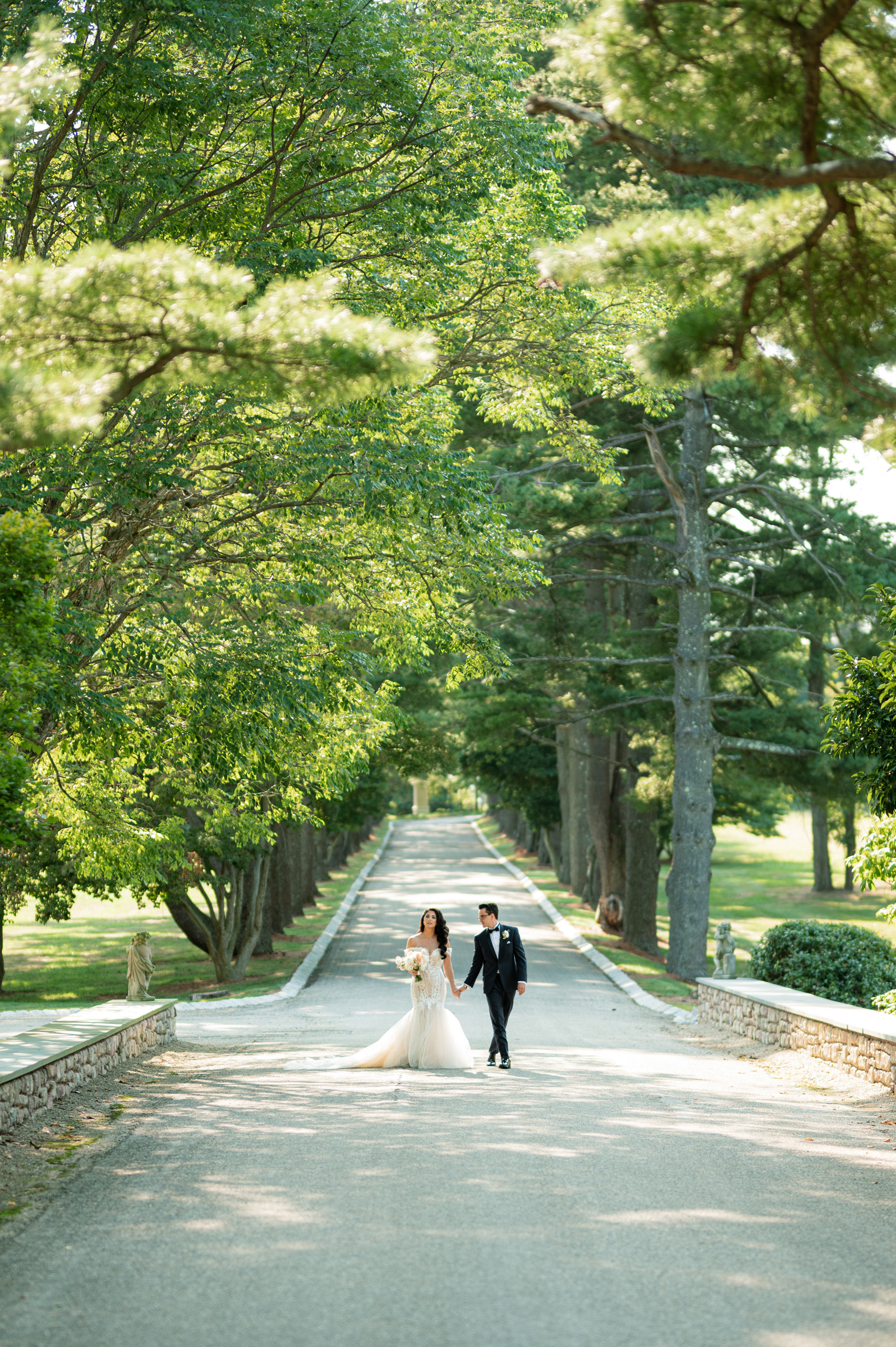a bride and groom walking down a road