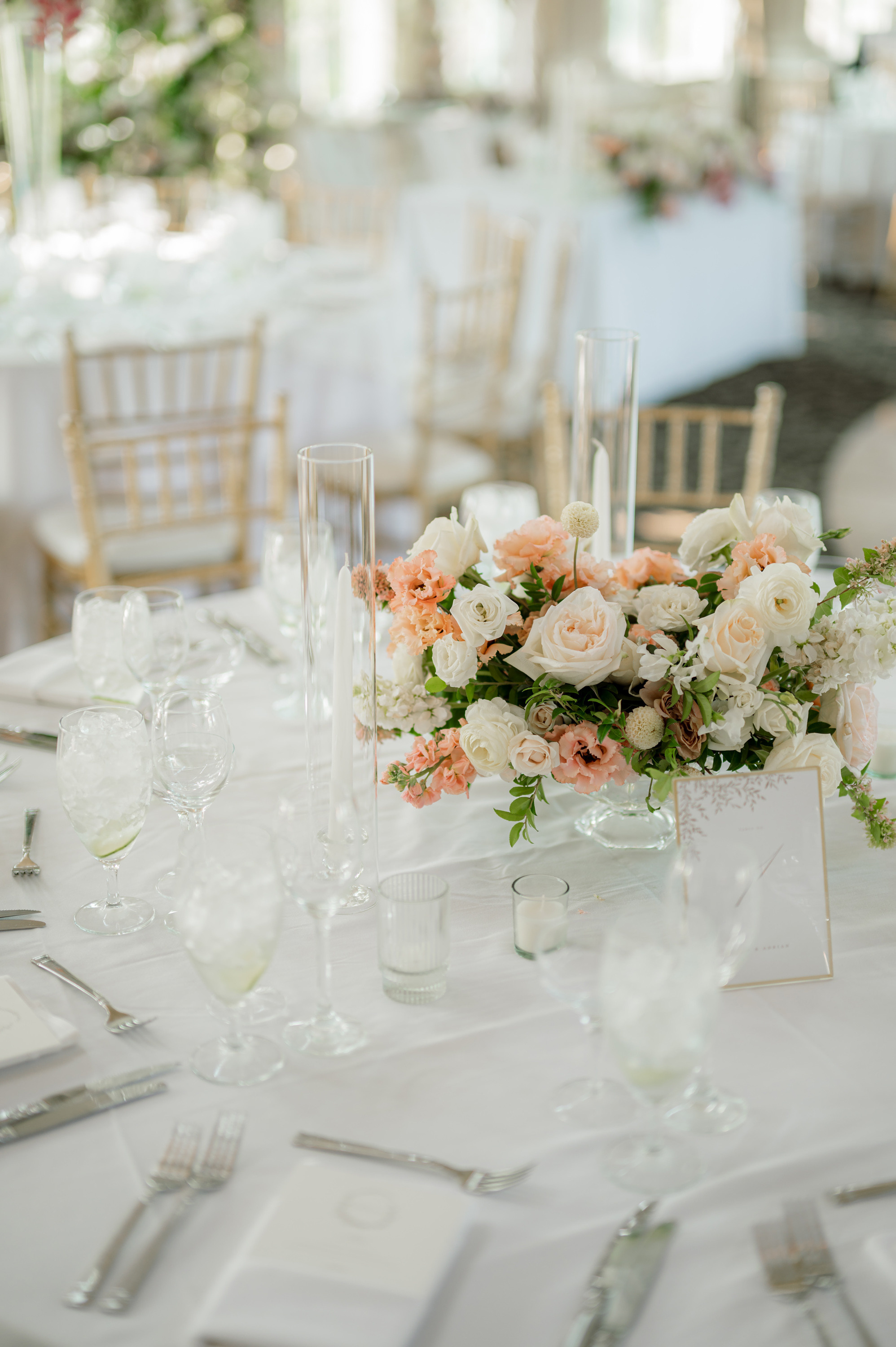 a table with white and pink flowers and silverware