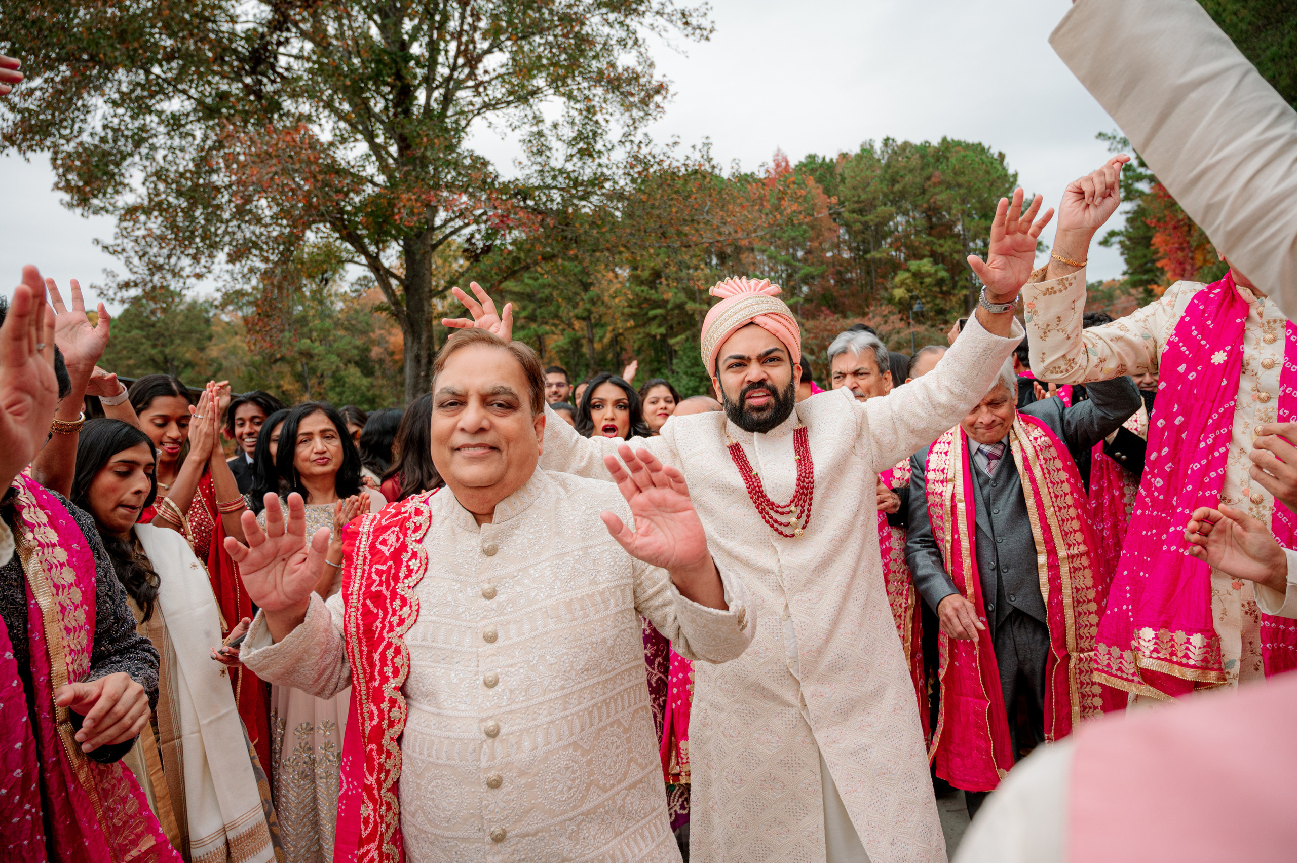 a man in a white suit and a woman in a pink dress