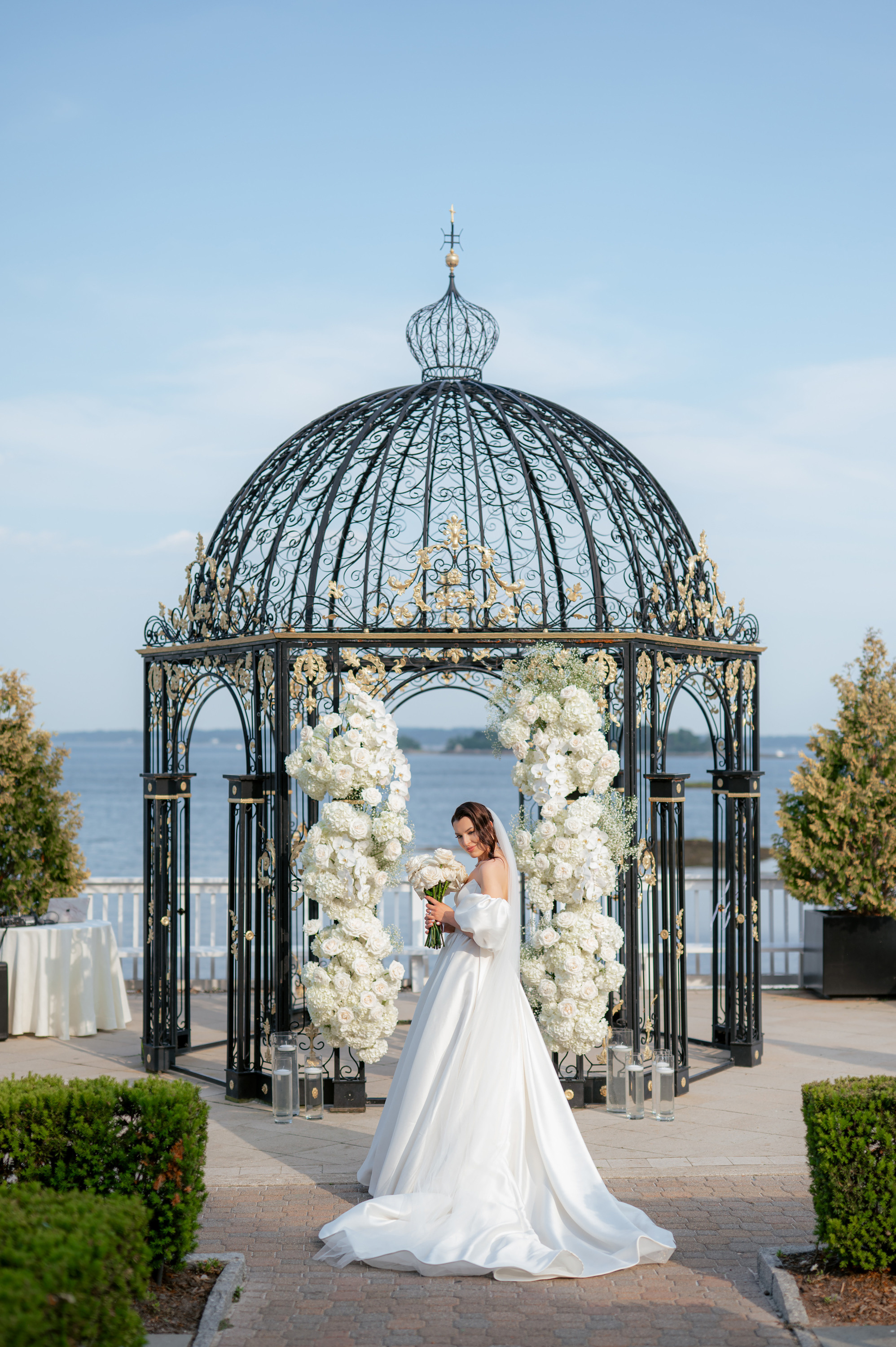 a bride standing in front of a gaze with white flowers
