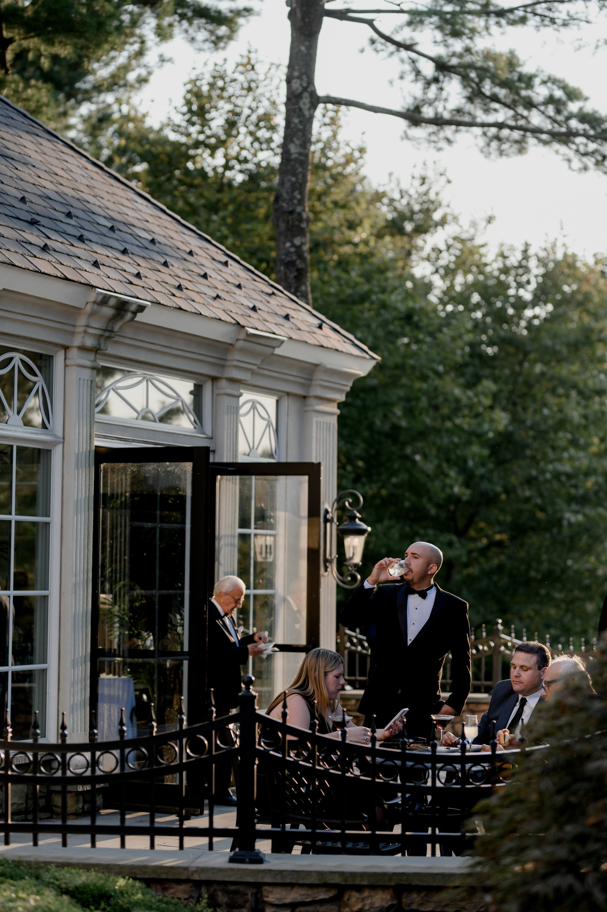 a man in a tuxed suit standing on a balcony