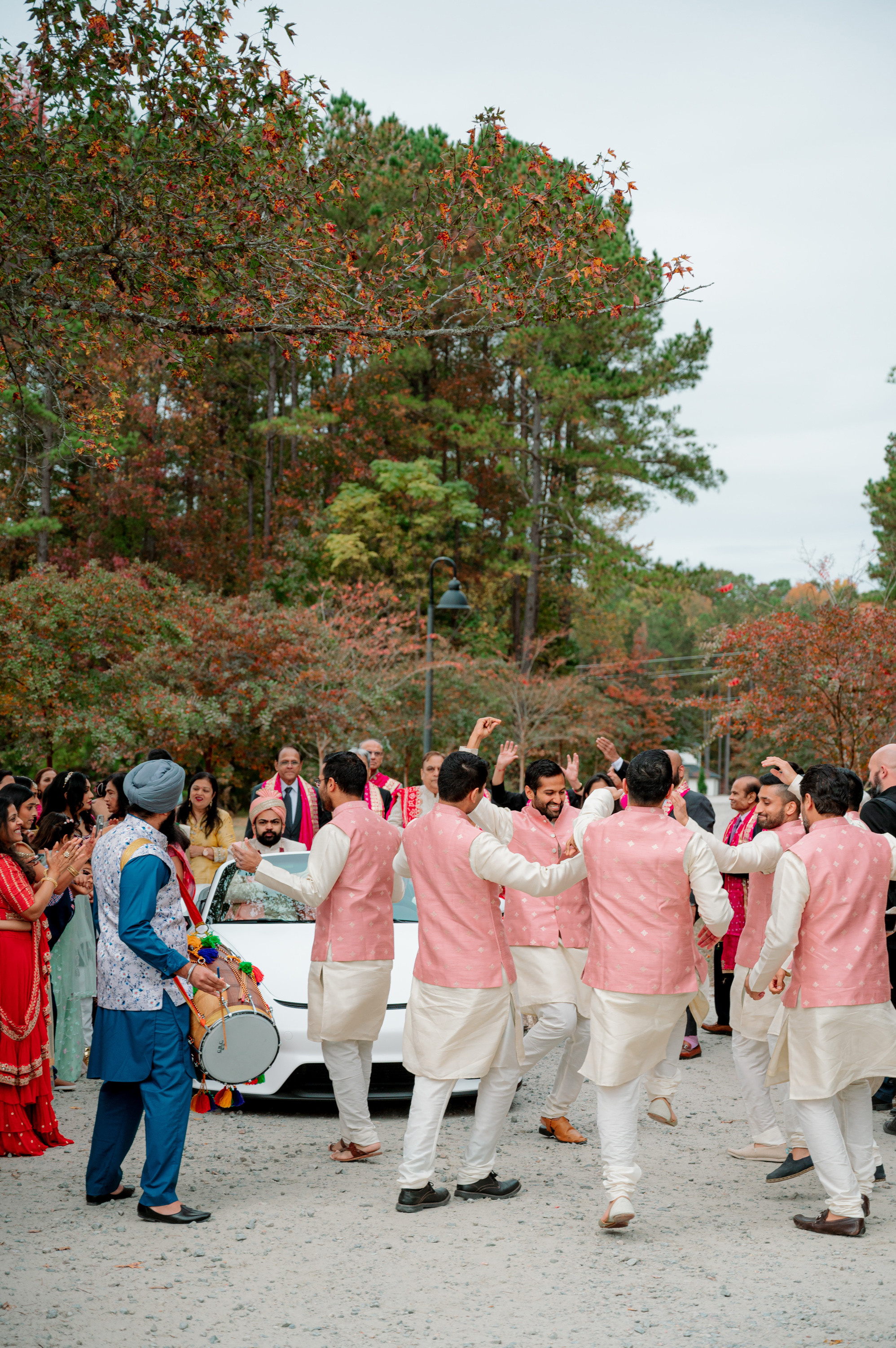 a group of people dancing in front of a car