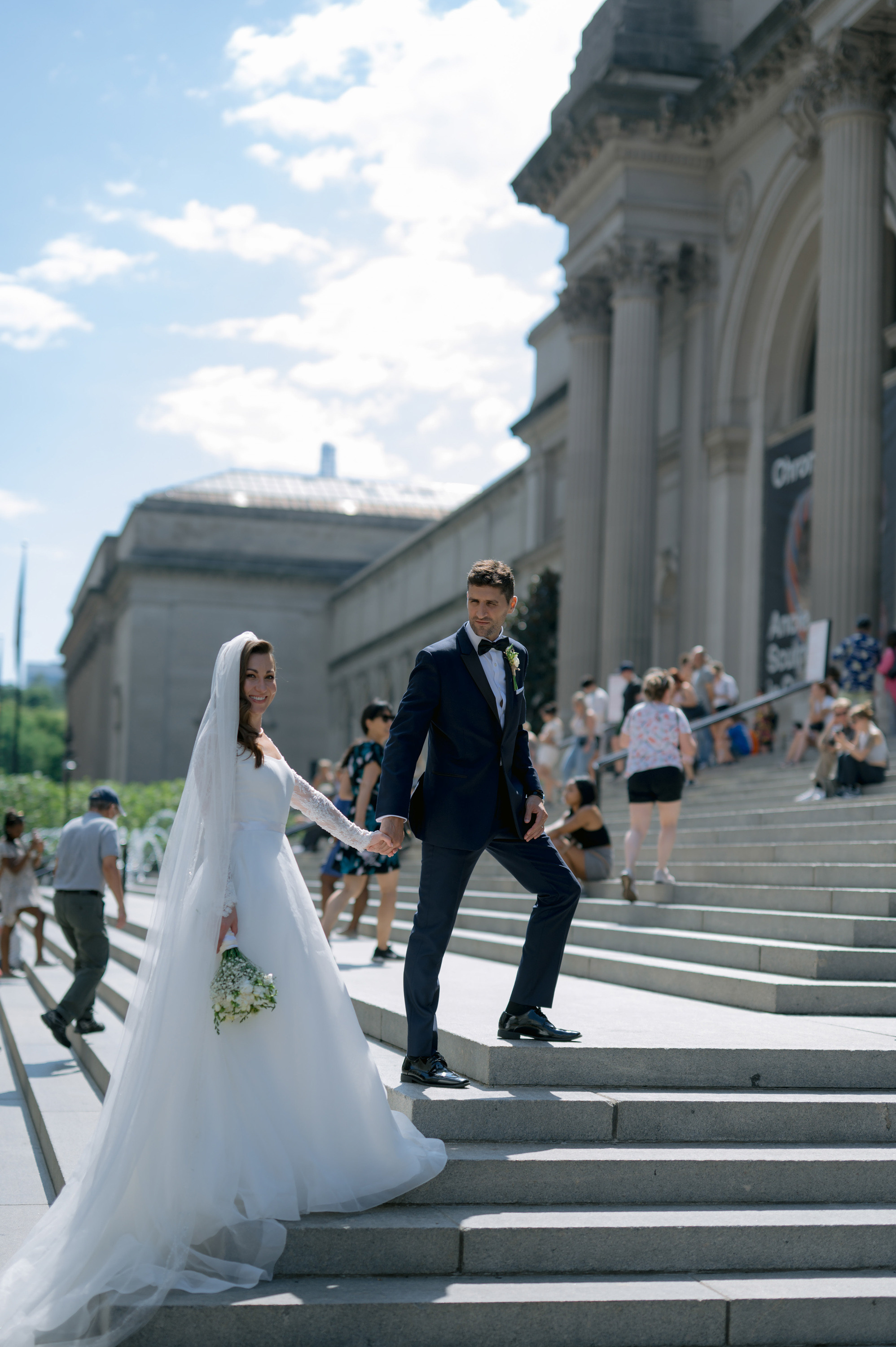 a bride and groom walking down the stairs