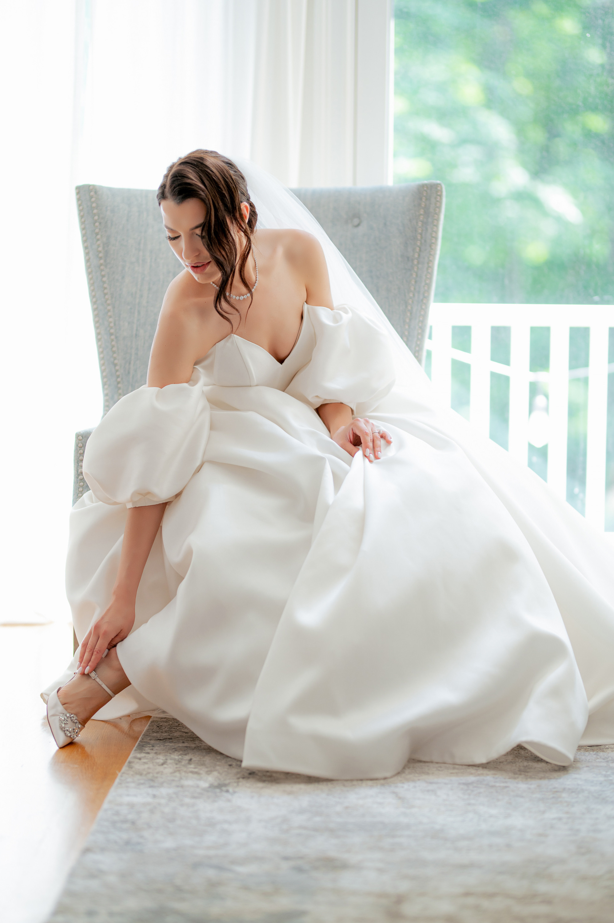 a woman in a white dress sitting on a chair