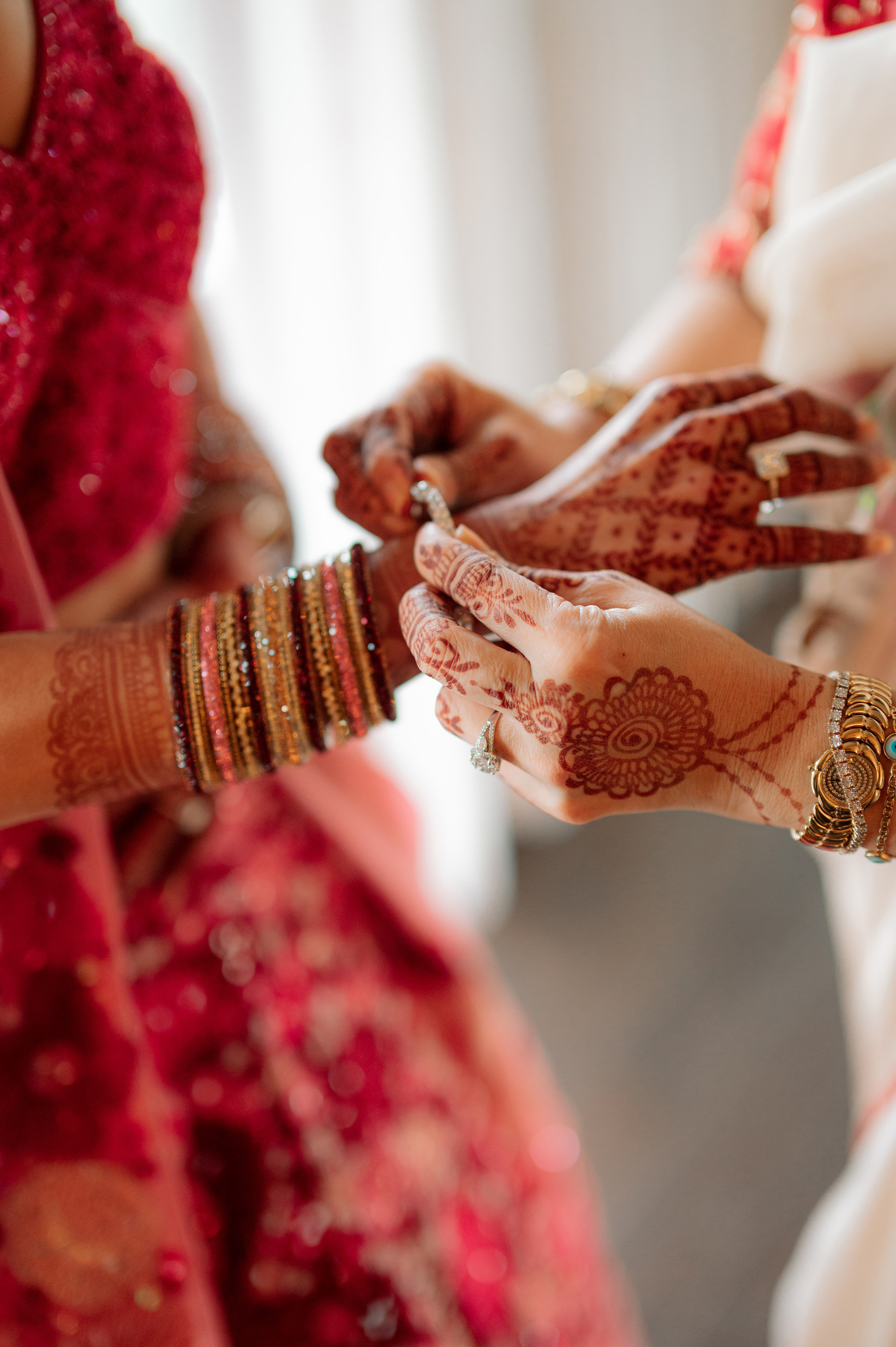 a bride putting a ring on her bridesmaring