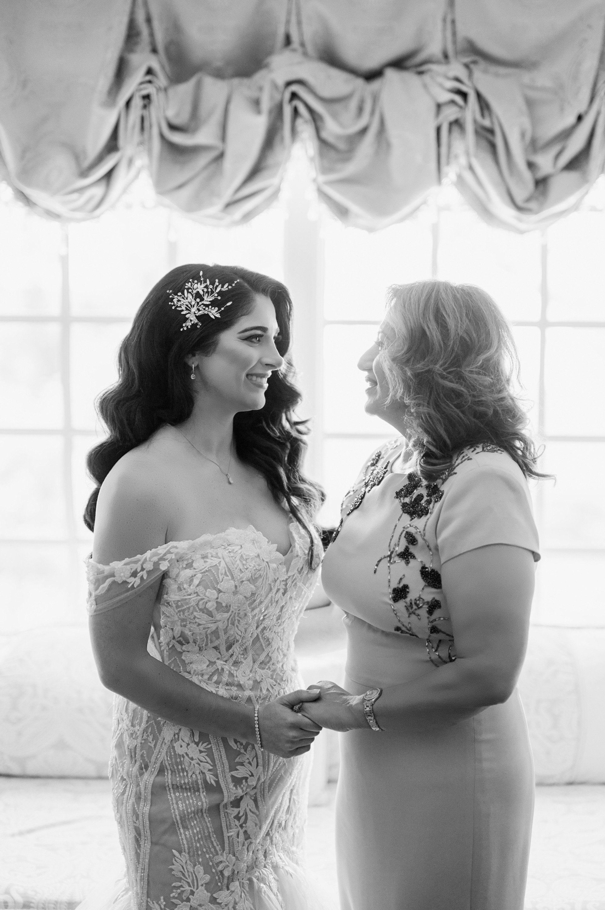 a bride and her mother share a moment before the wedding ceremony