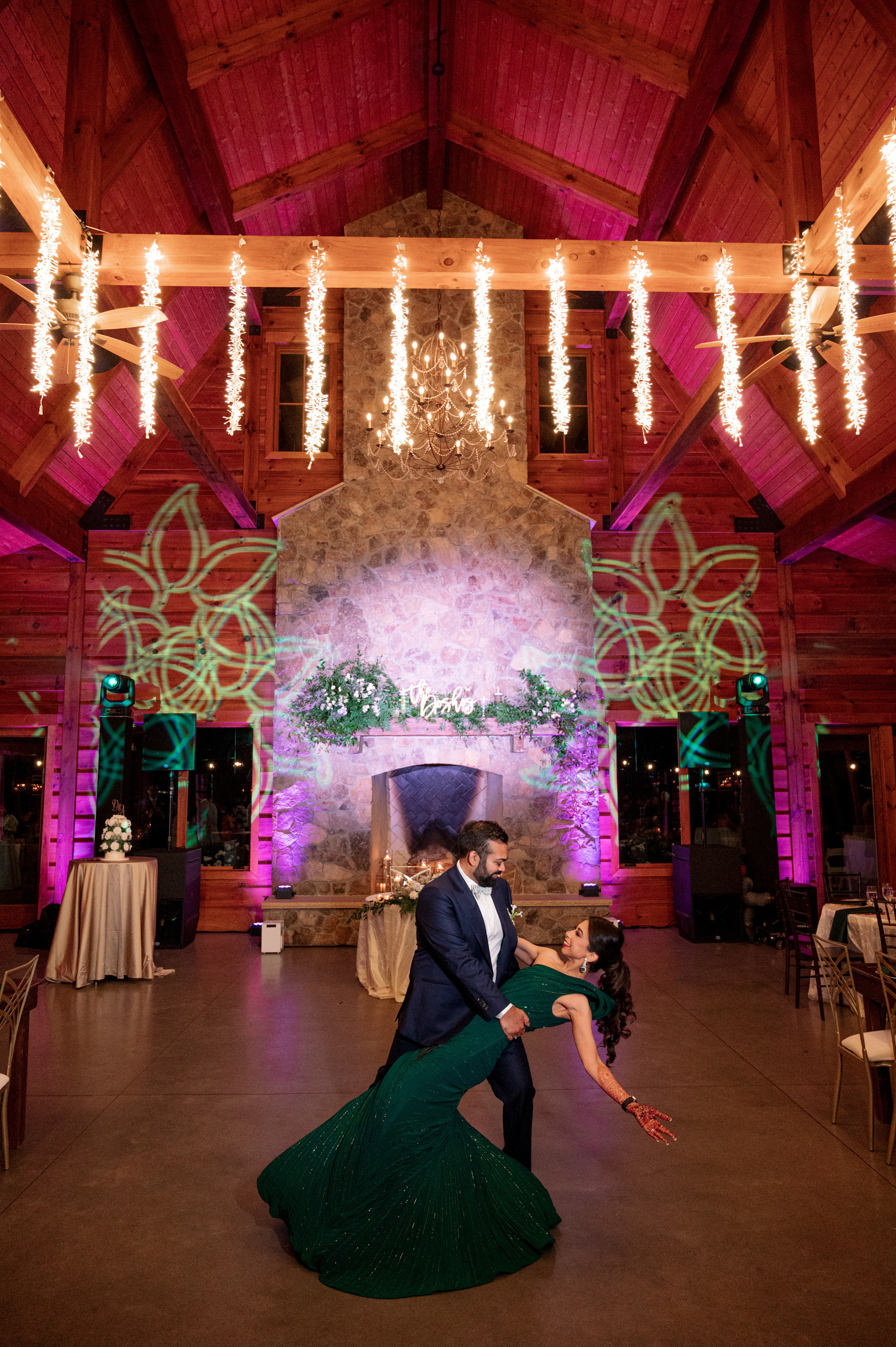 a couple dancing in a large room with chandels