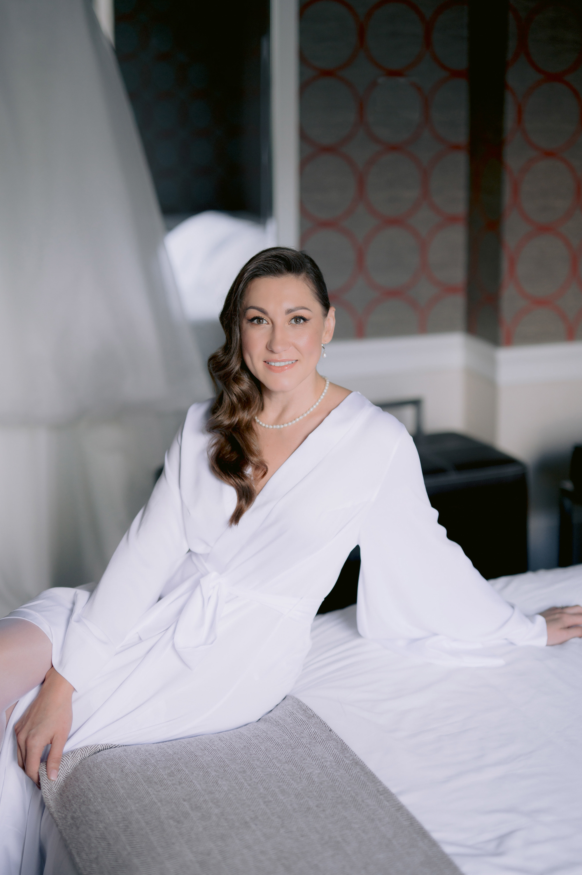 a woman in a white robe sitting on a bed