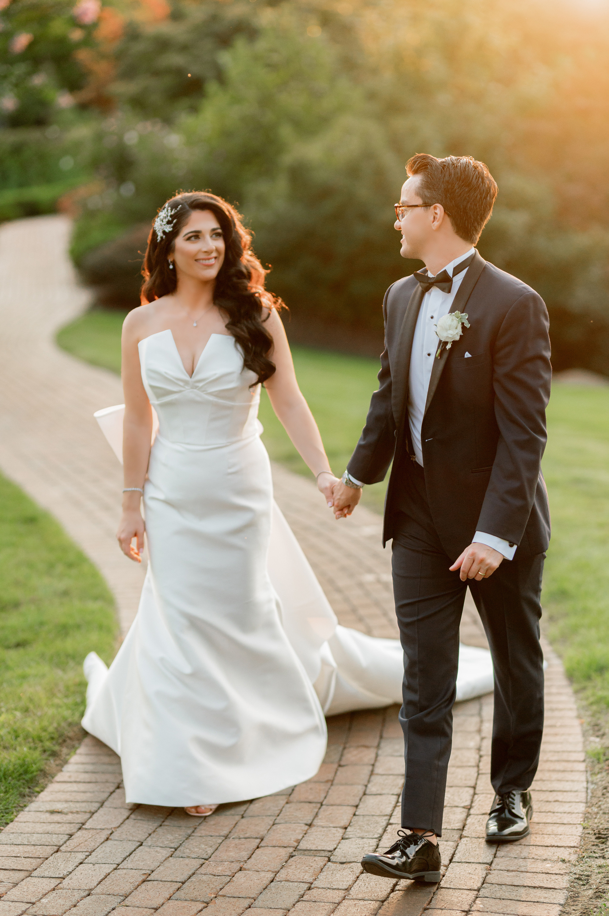 a bride and groom walking down a brick path