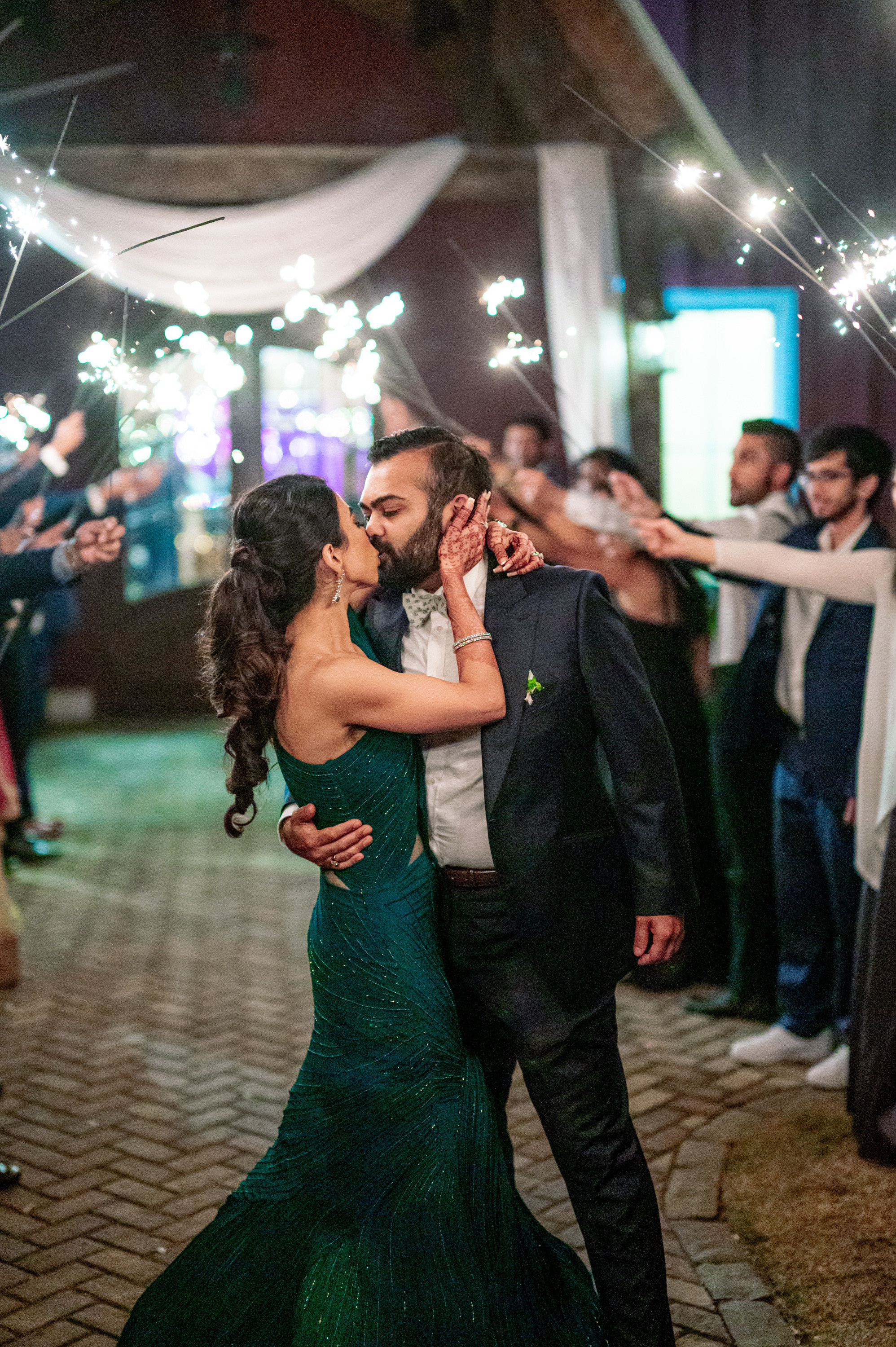 a couple kissing while holding sparkle sticks