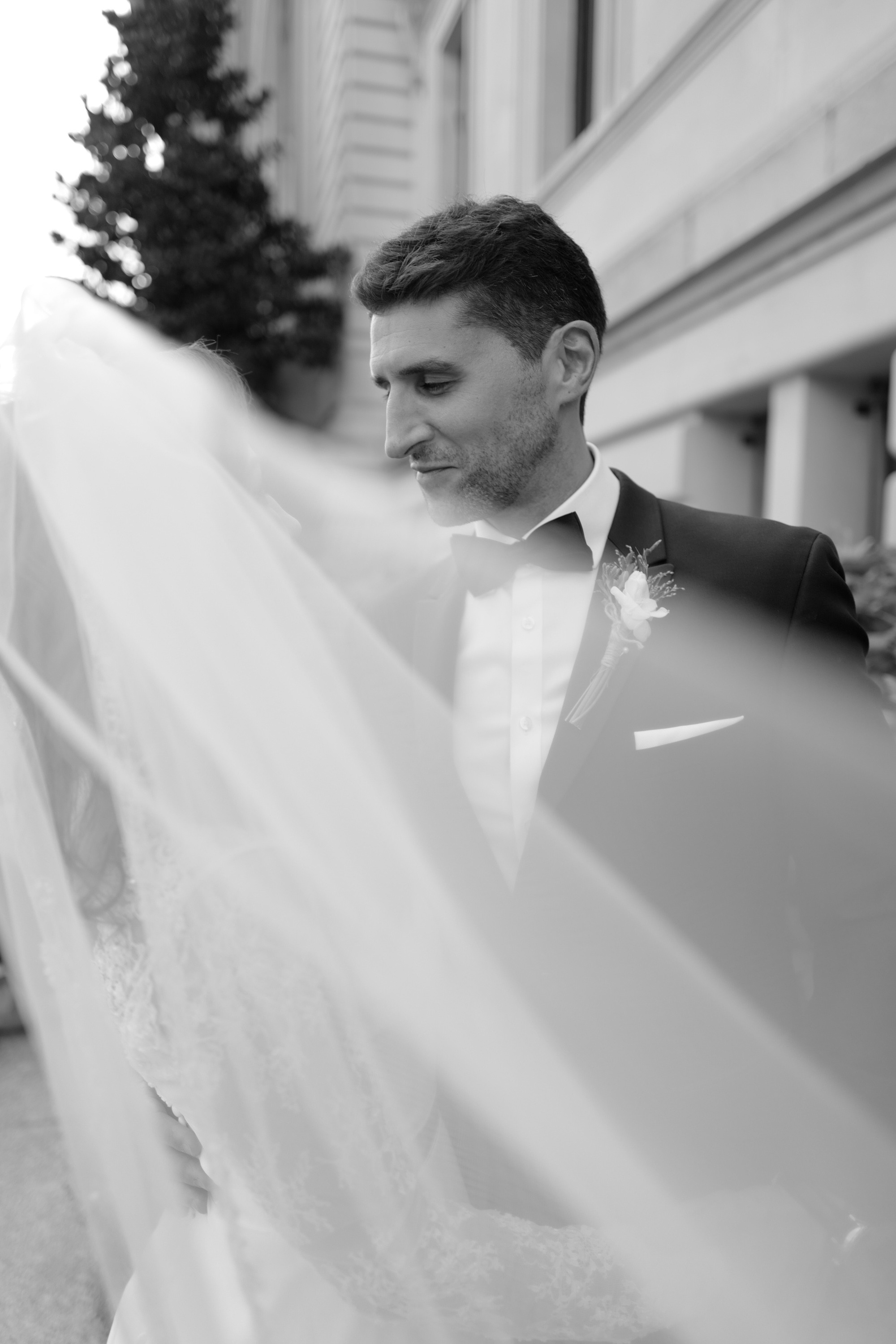a bride and groom are standing outside