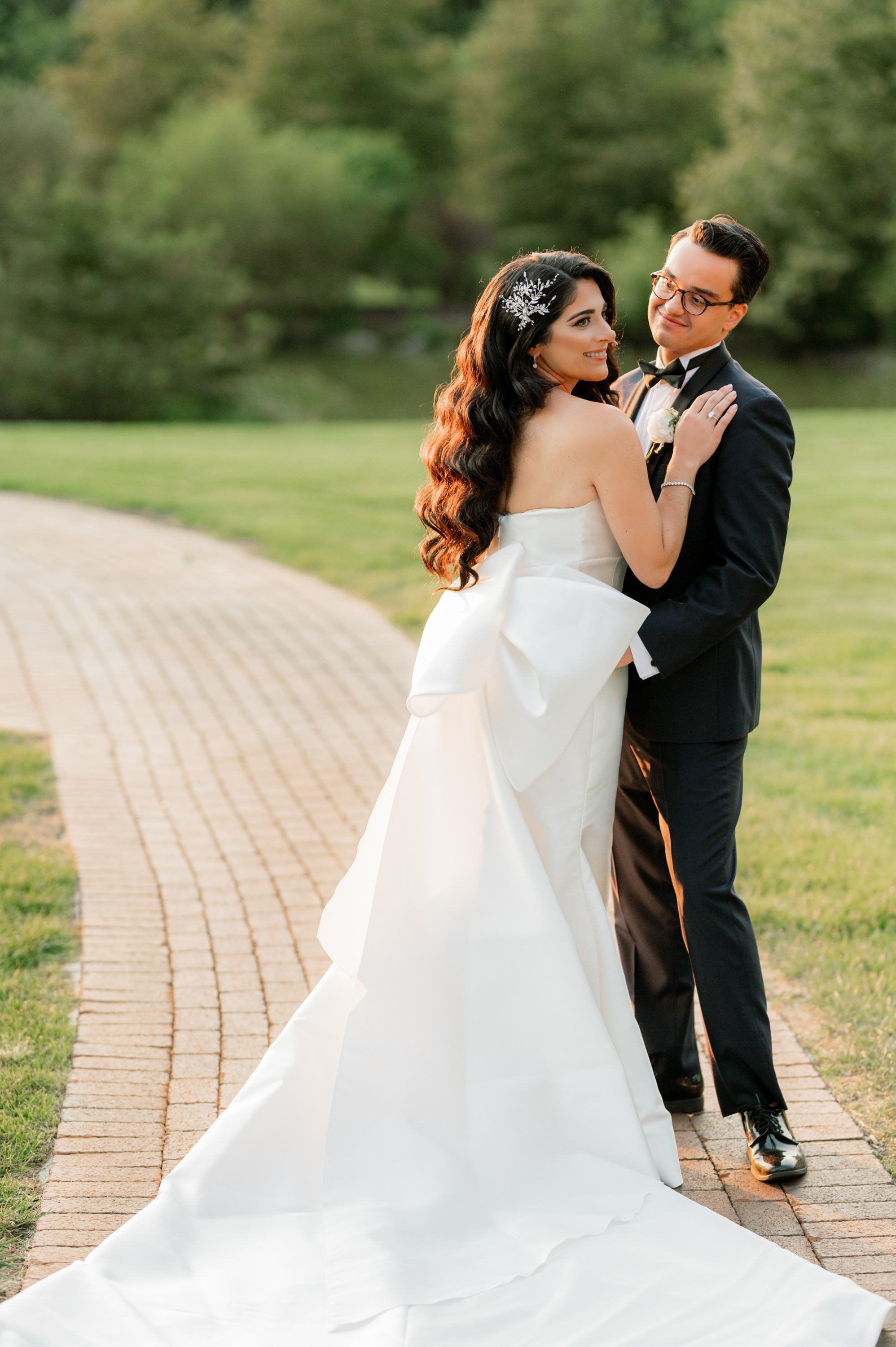 a bride and groom pose for a photo in the park