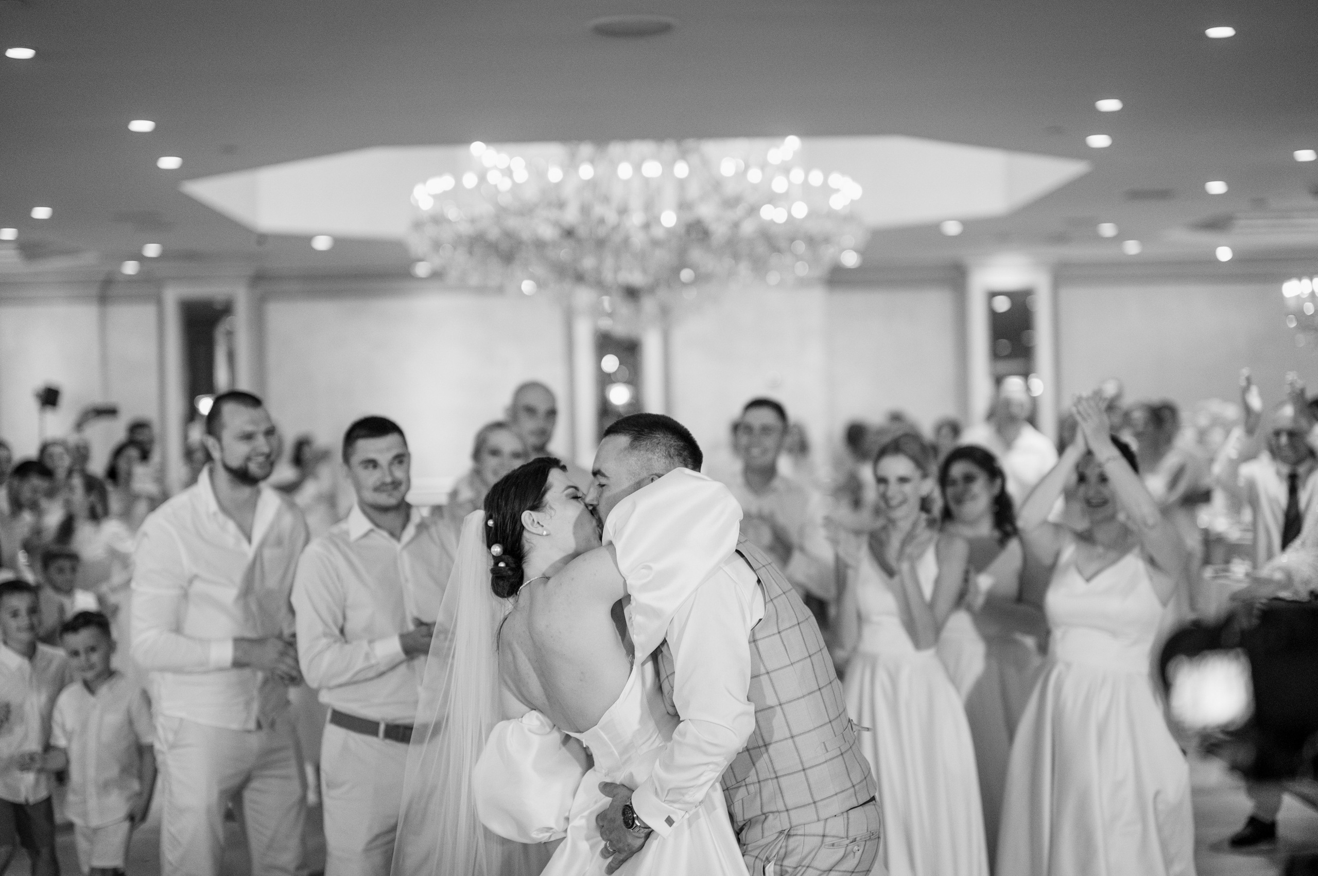 a bride and groom kissing in front of a crowd