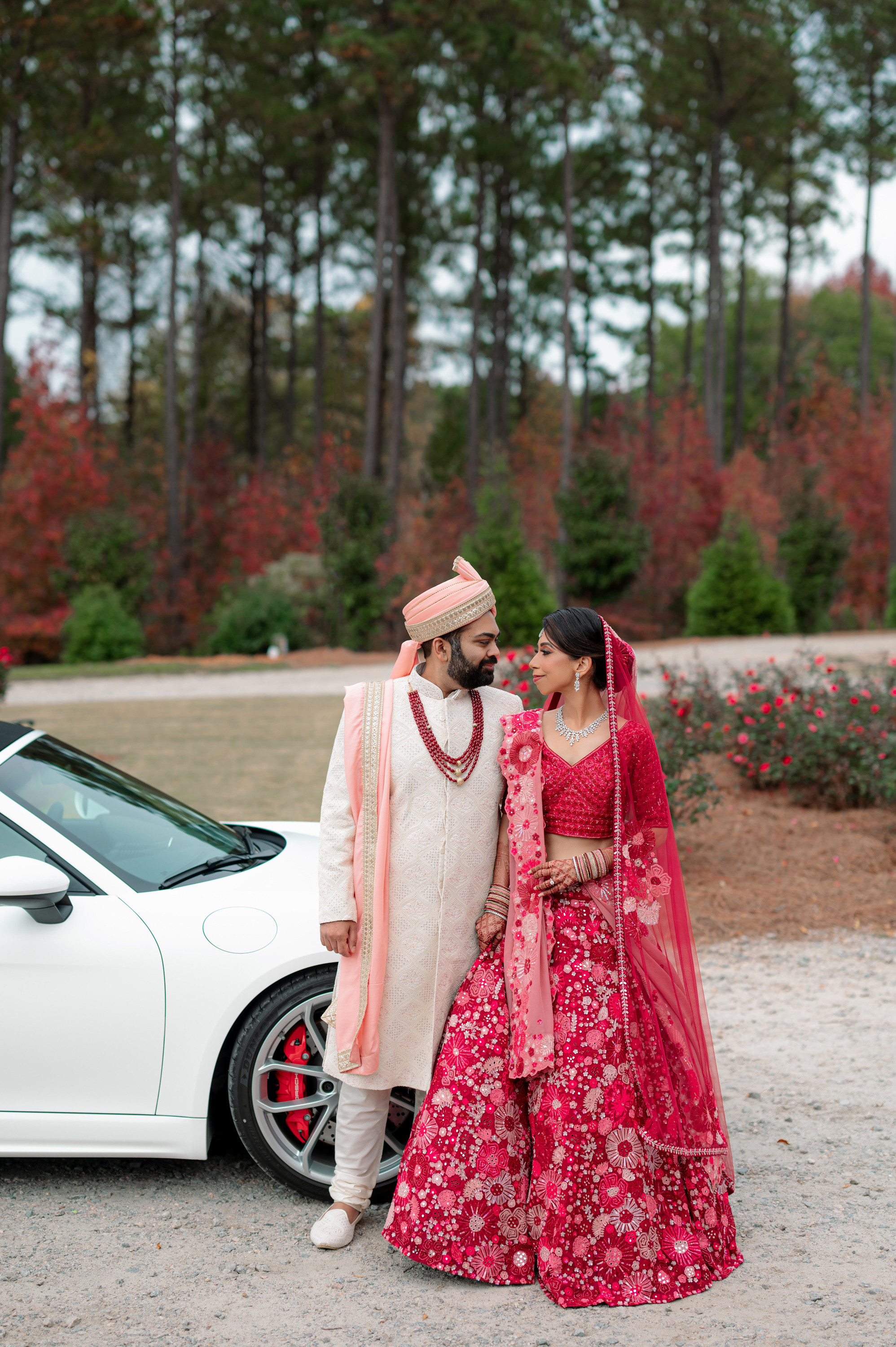 a couple standing next to a white car