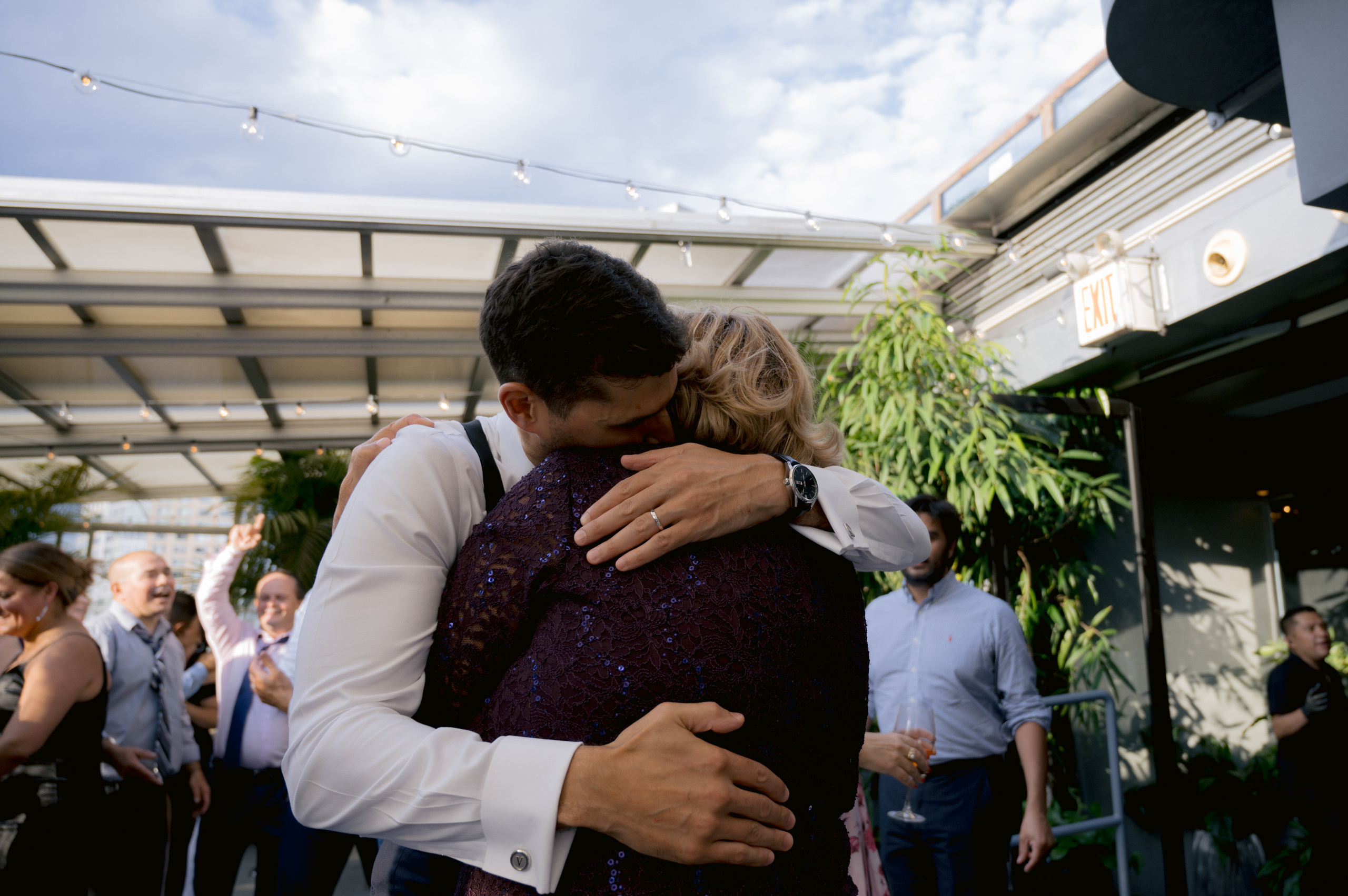 a couple hugging each other people in a courtyard