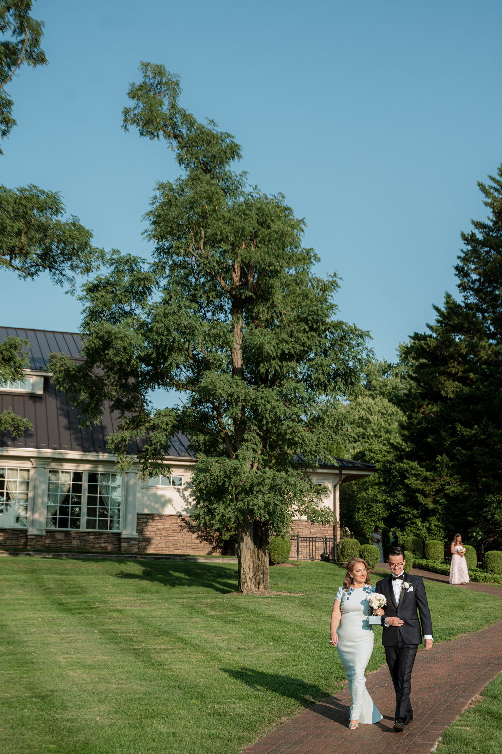 a bride and groom walking down a path