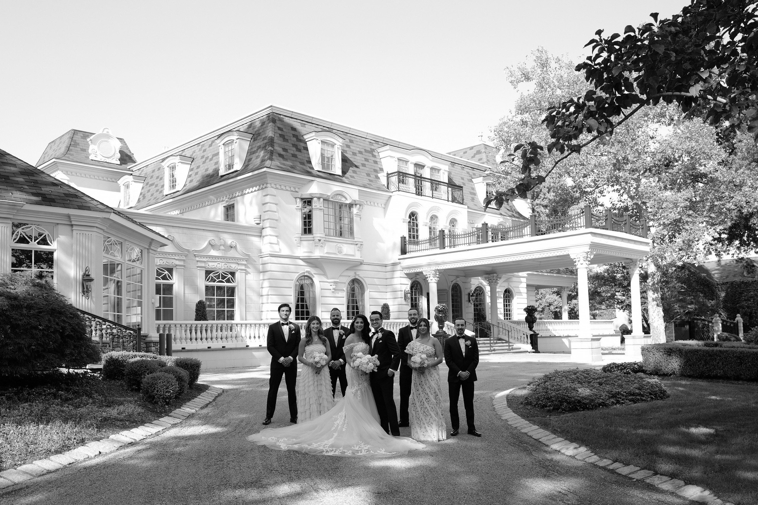 a group of people standing in front of a large house