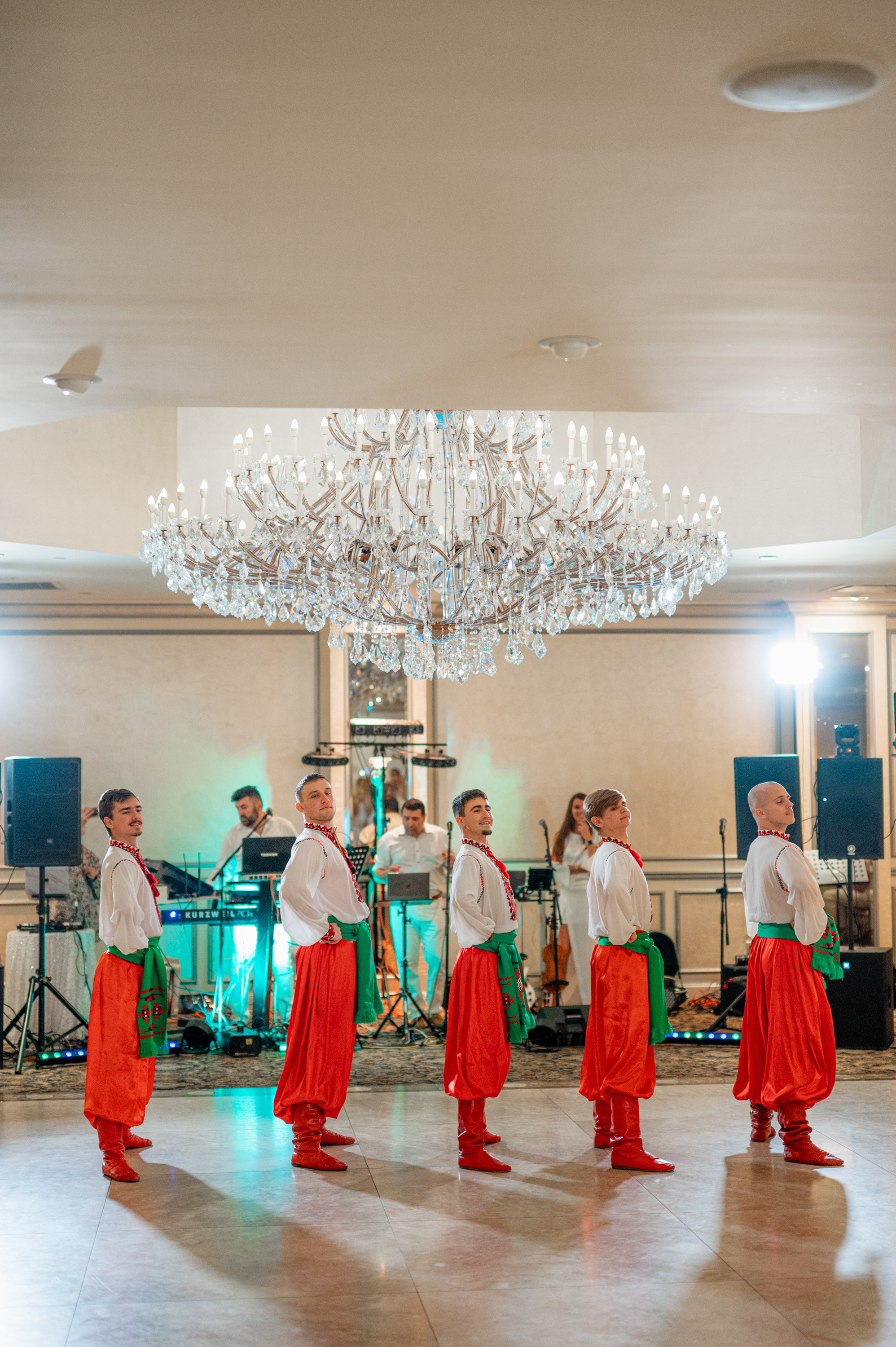 a group of people in a room with a chandel