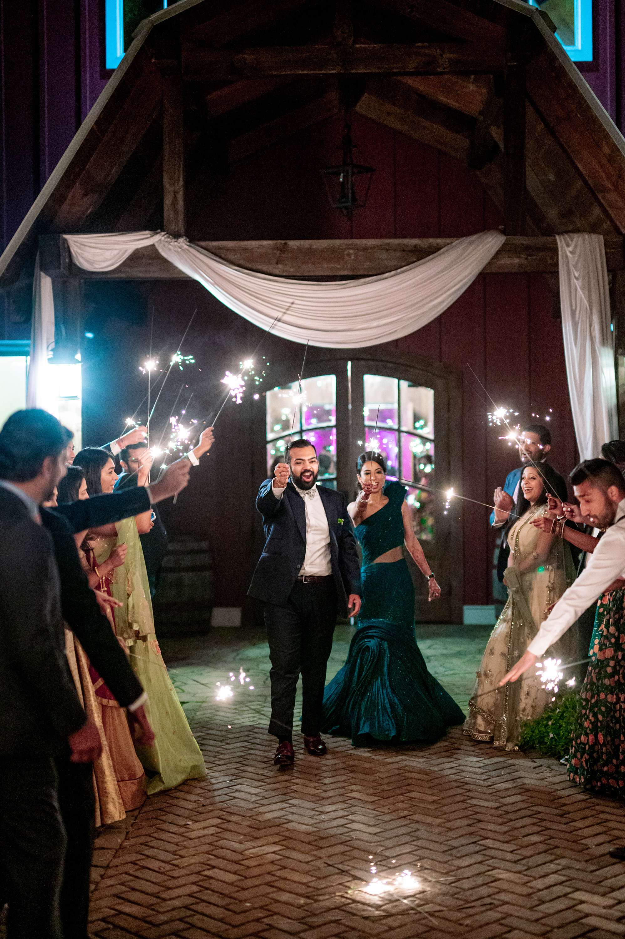 a group of people holding sparkle sticks in a barn