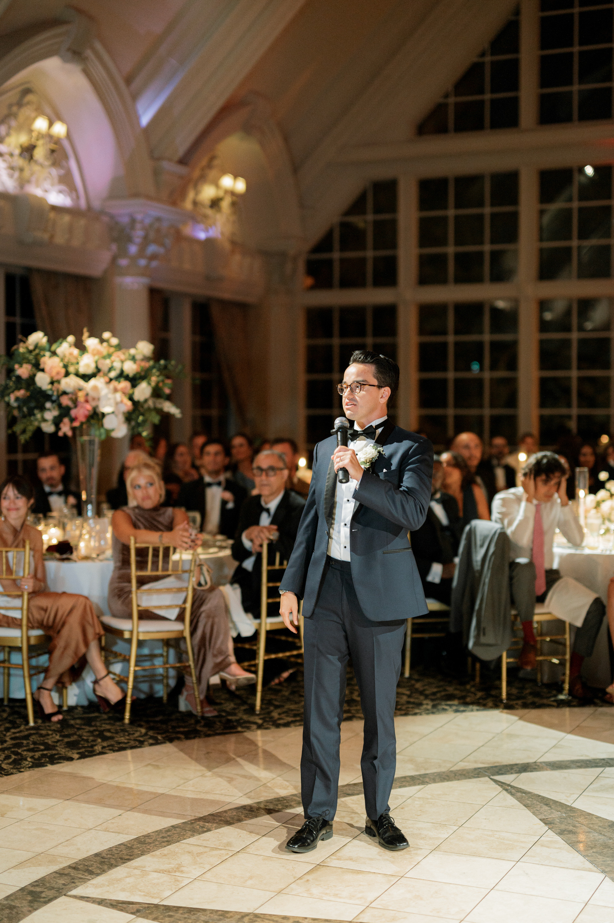 a man in a suit standing on a dance floor