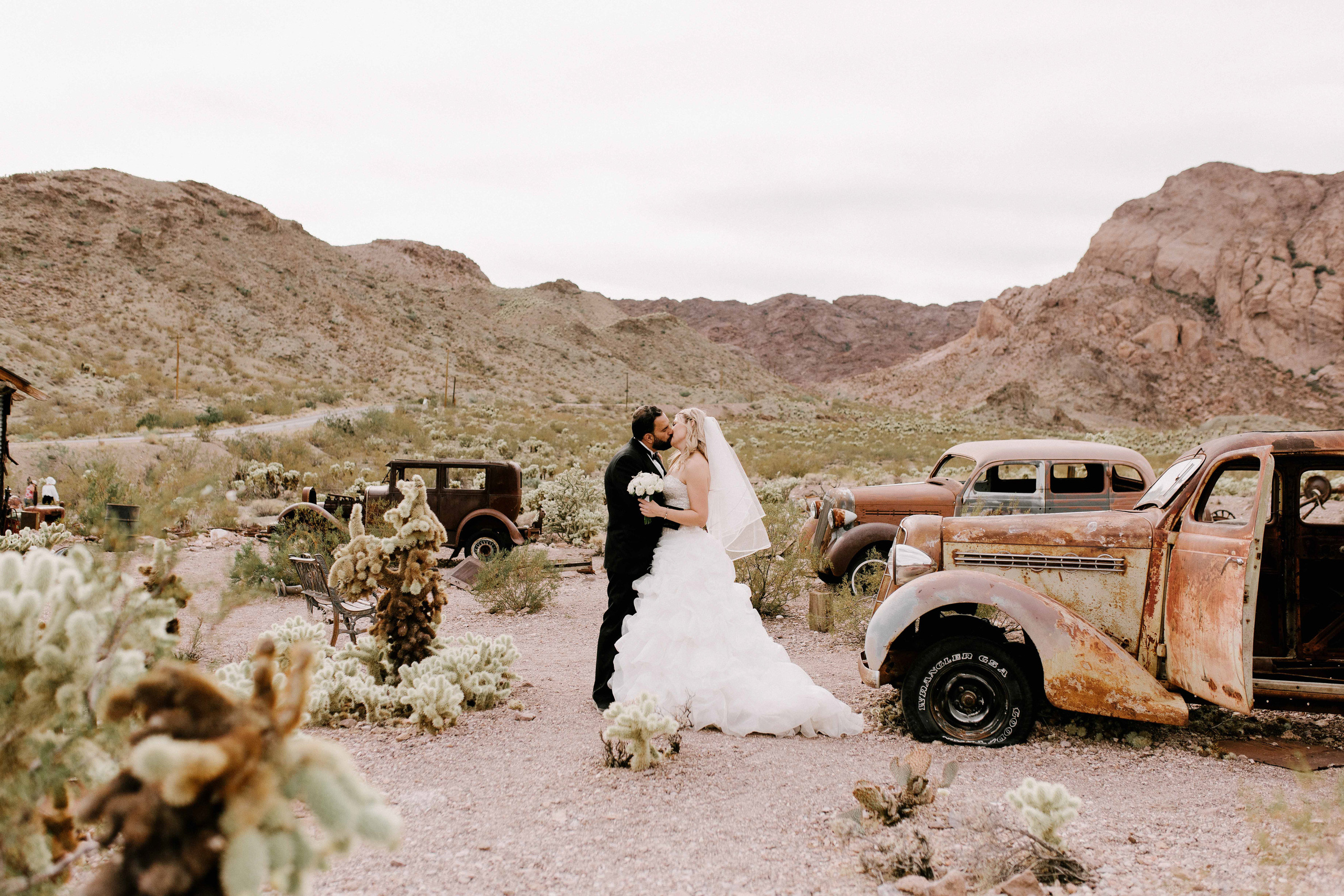a bride and groom standing in front of a truck