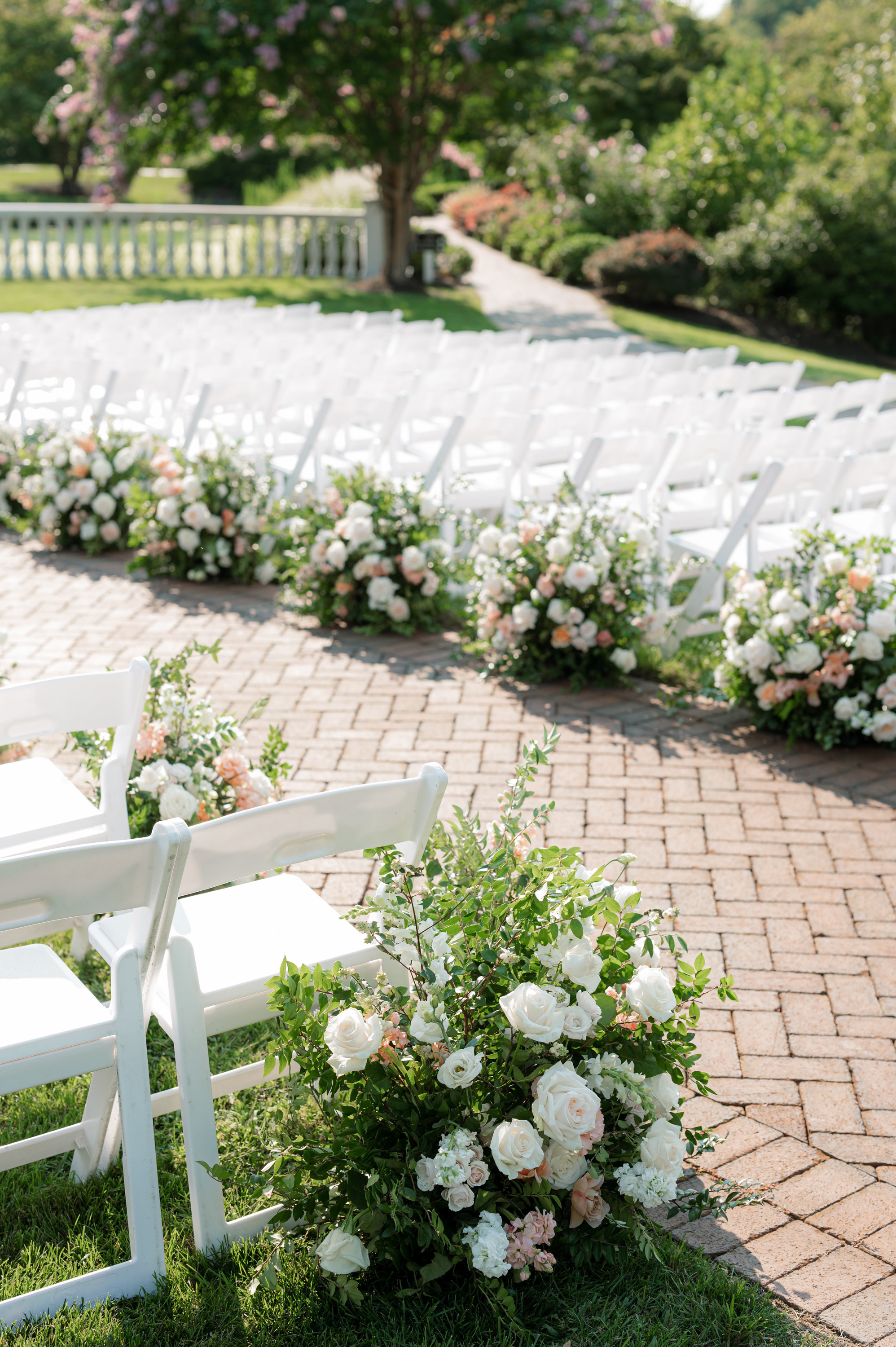 a wedding ceremony with white chairs and flowers