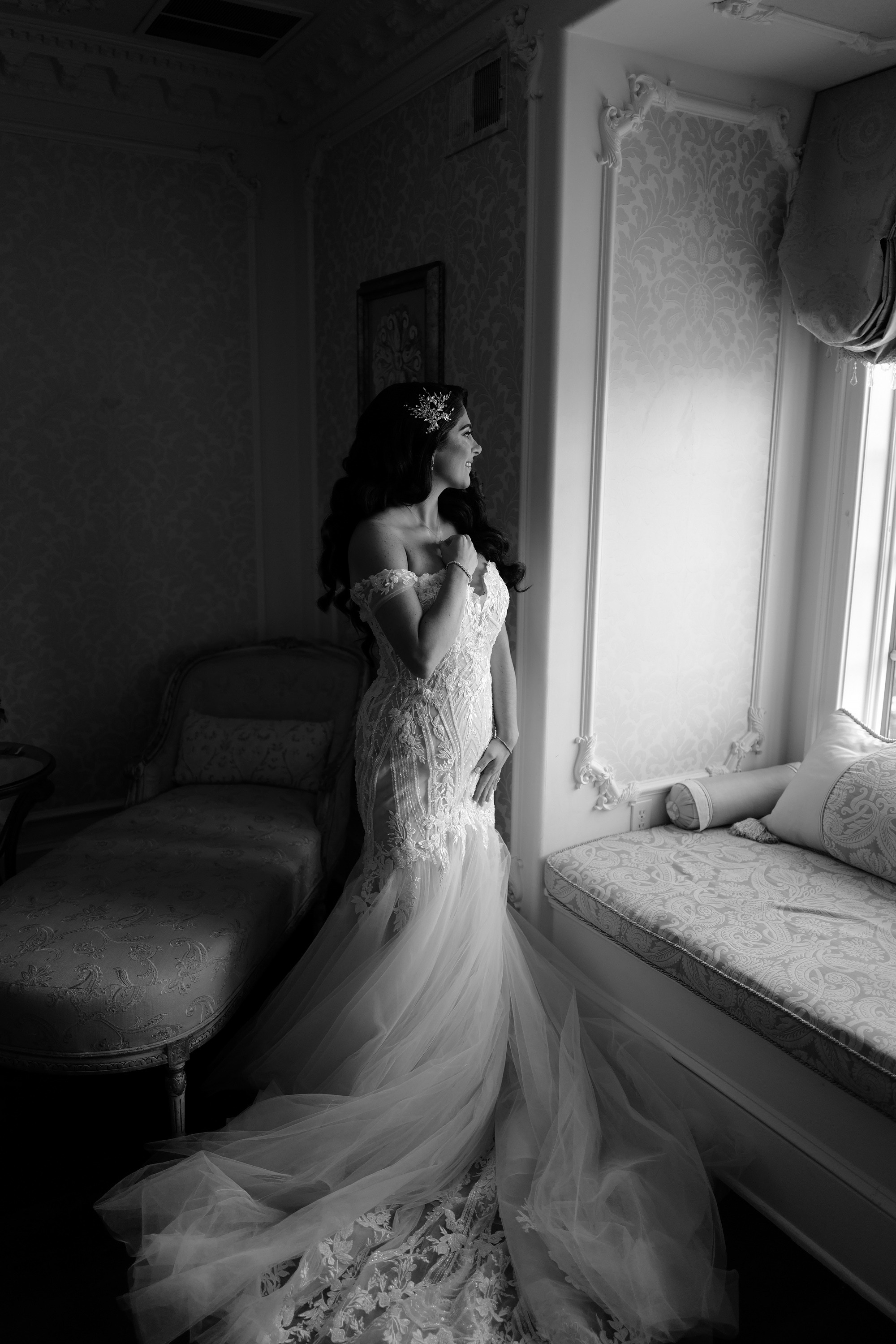 a woman in a wedding dress is looking out the window
