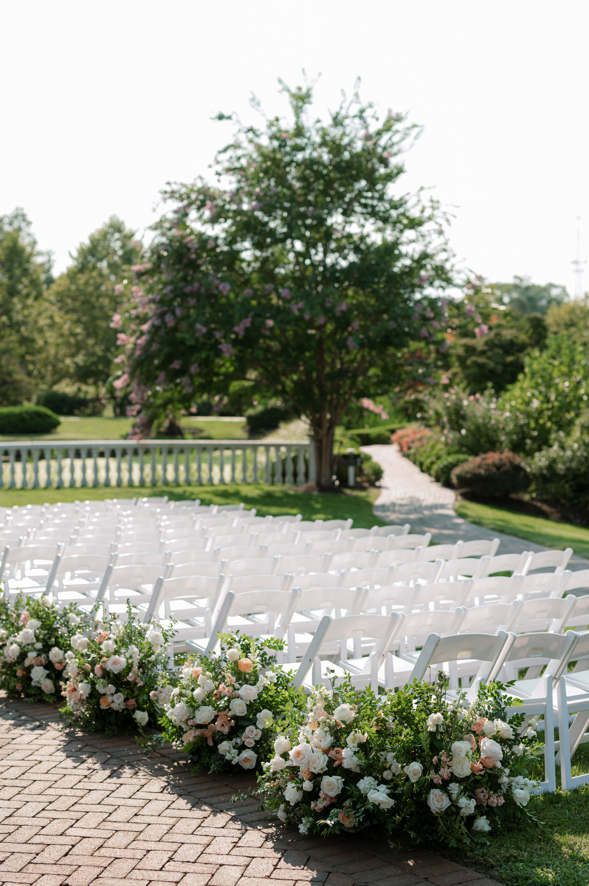 a row of white chairs with flowers on them