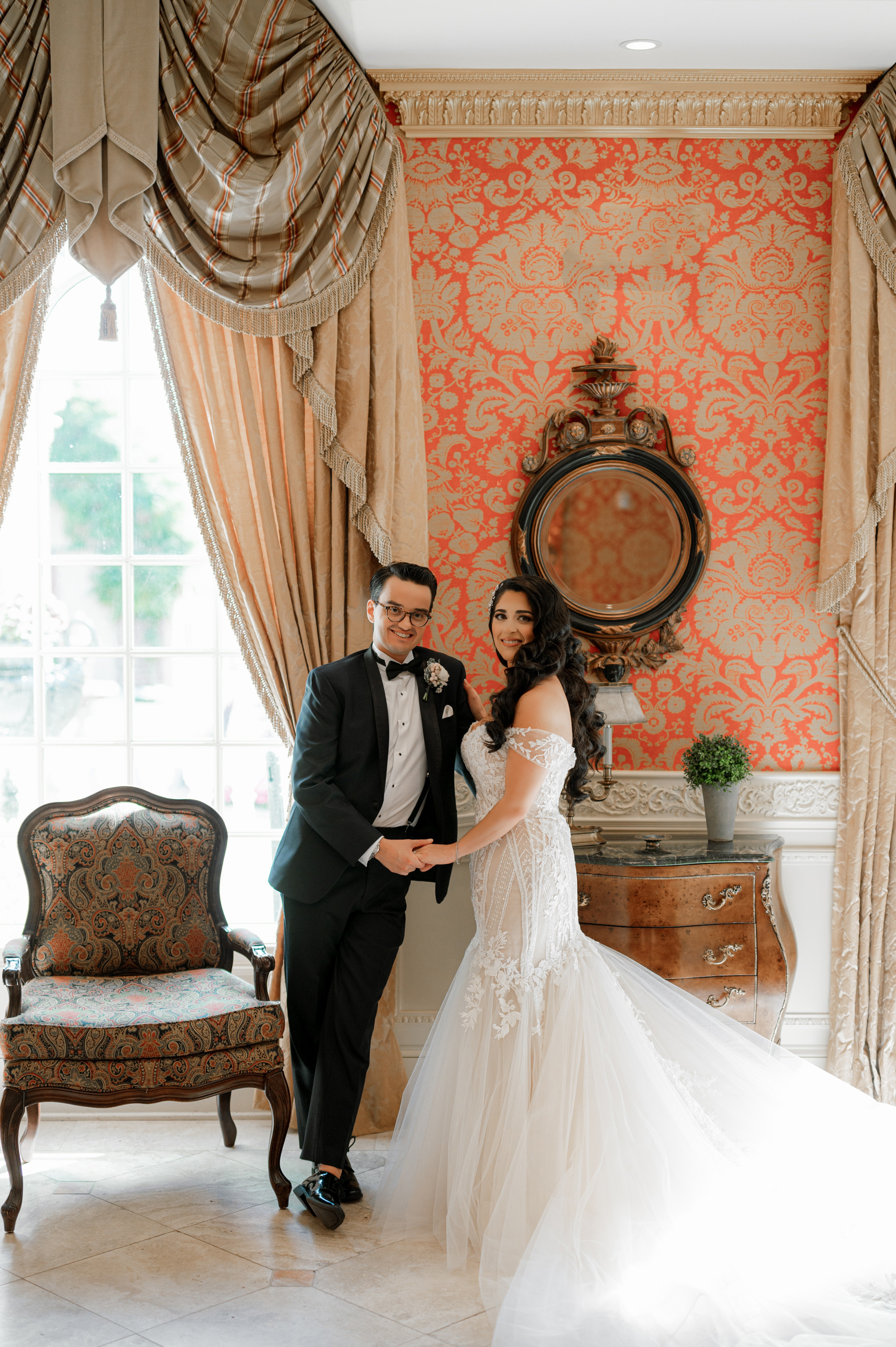 a bride and groom pose for a photo in a room
