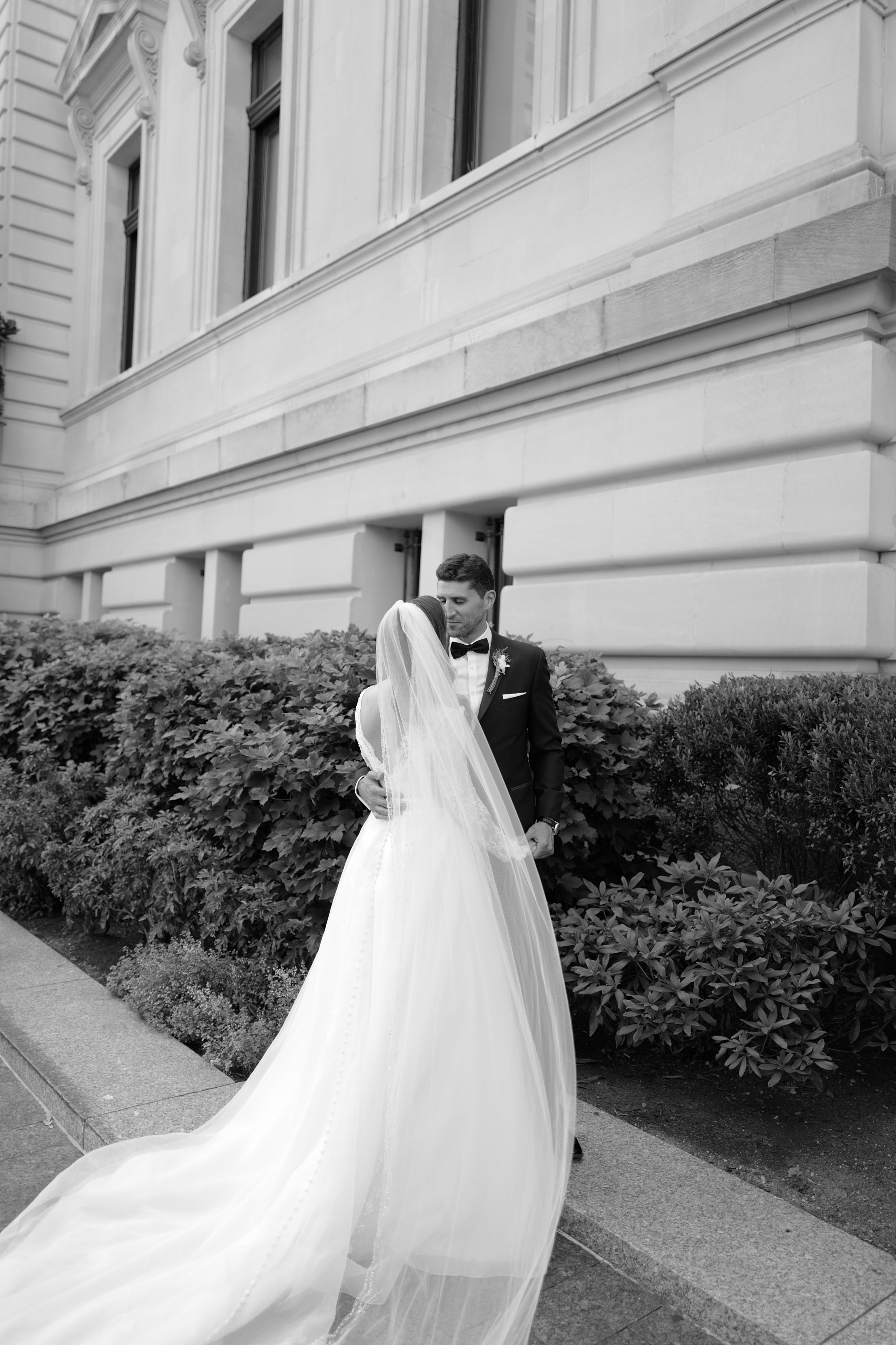 a bride and groom walking down the street