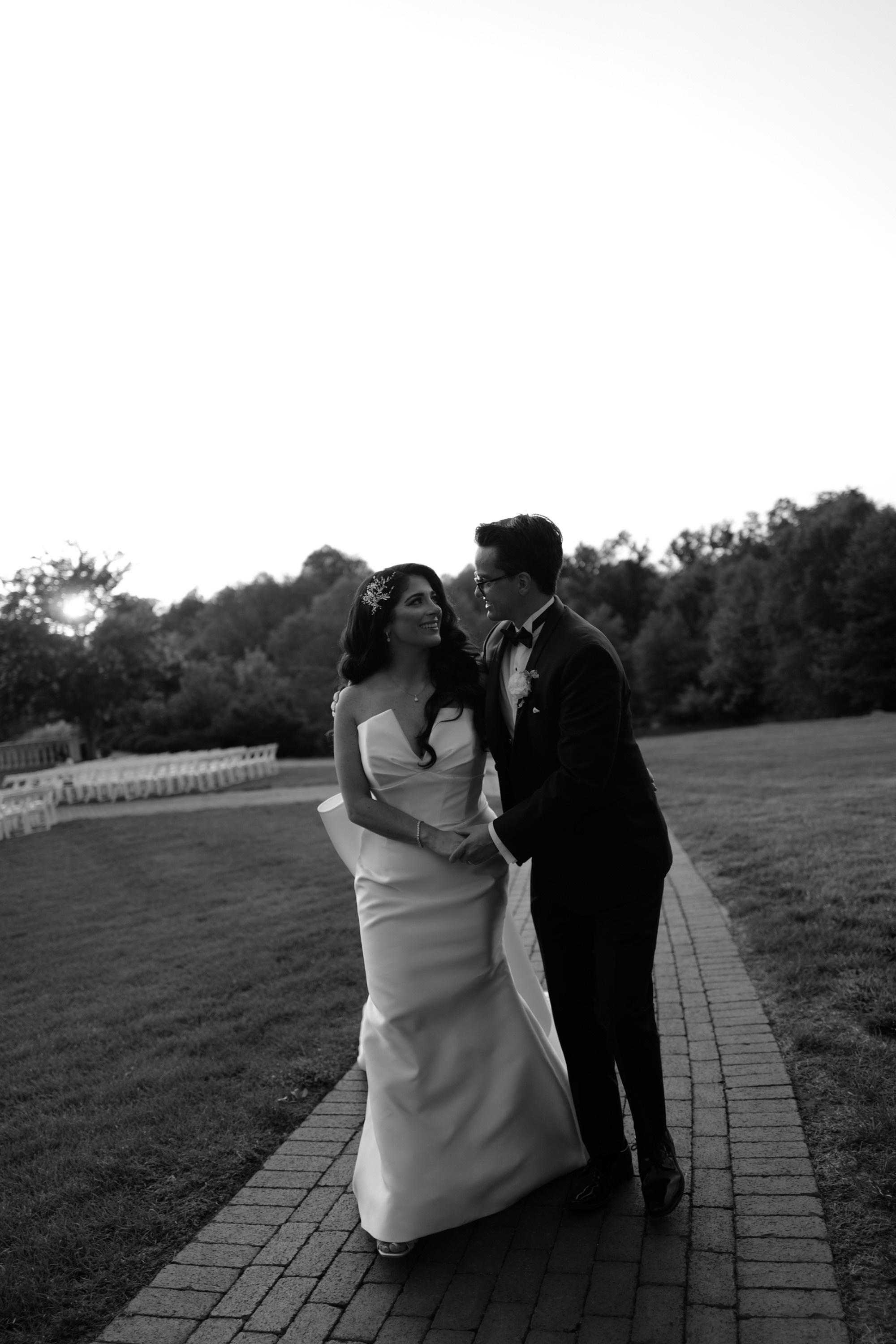 a bride and groom kissing in the park