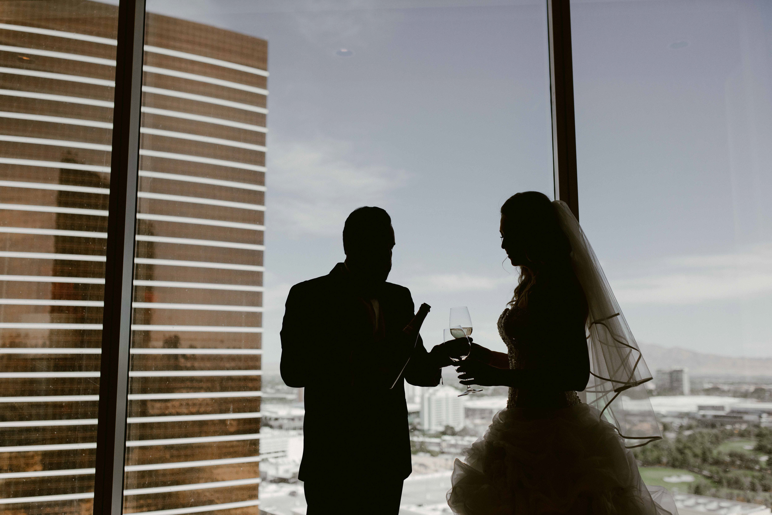 a bride and groom standing in front of a window