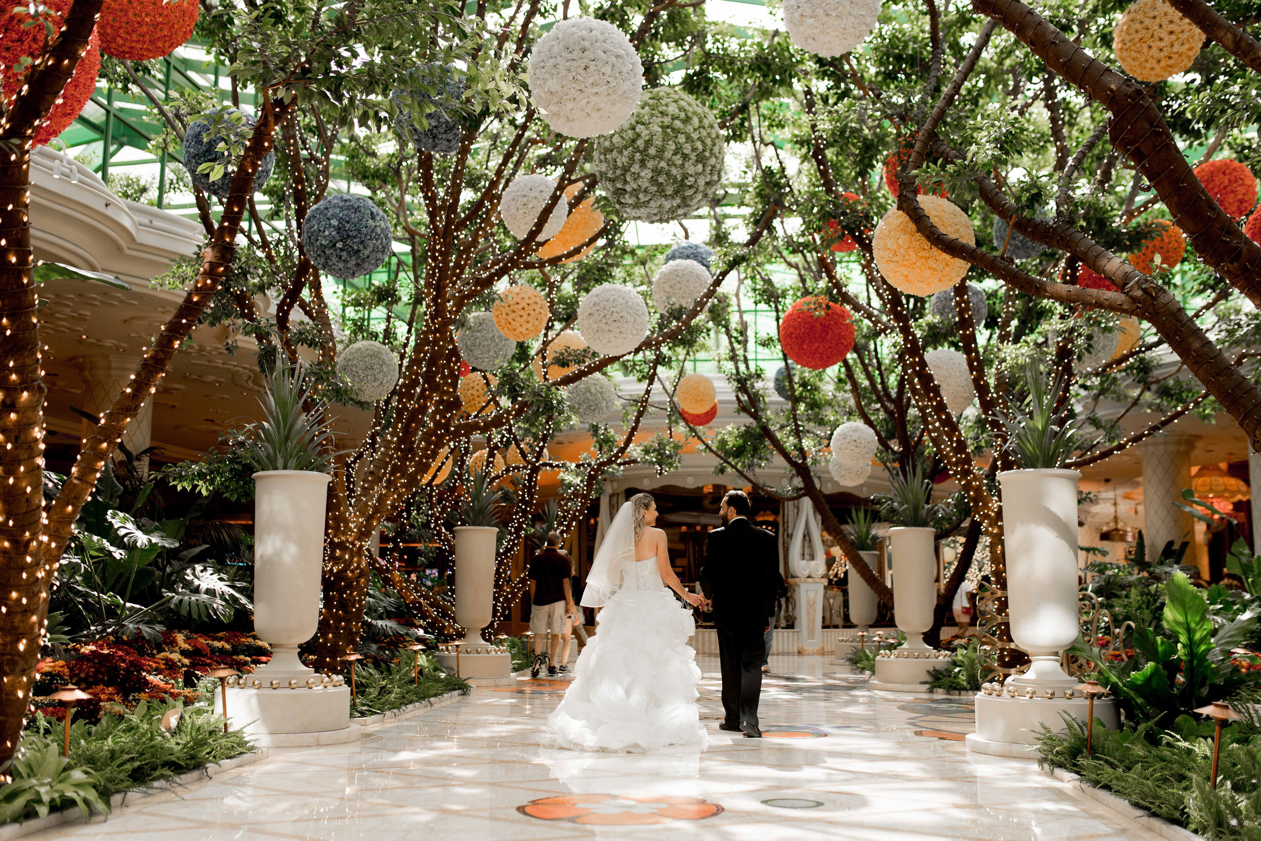 a couple walking through a large atrium with lots of decorations