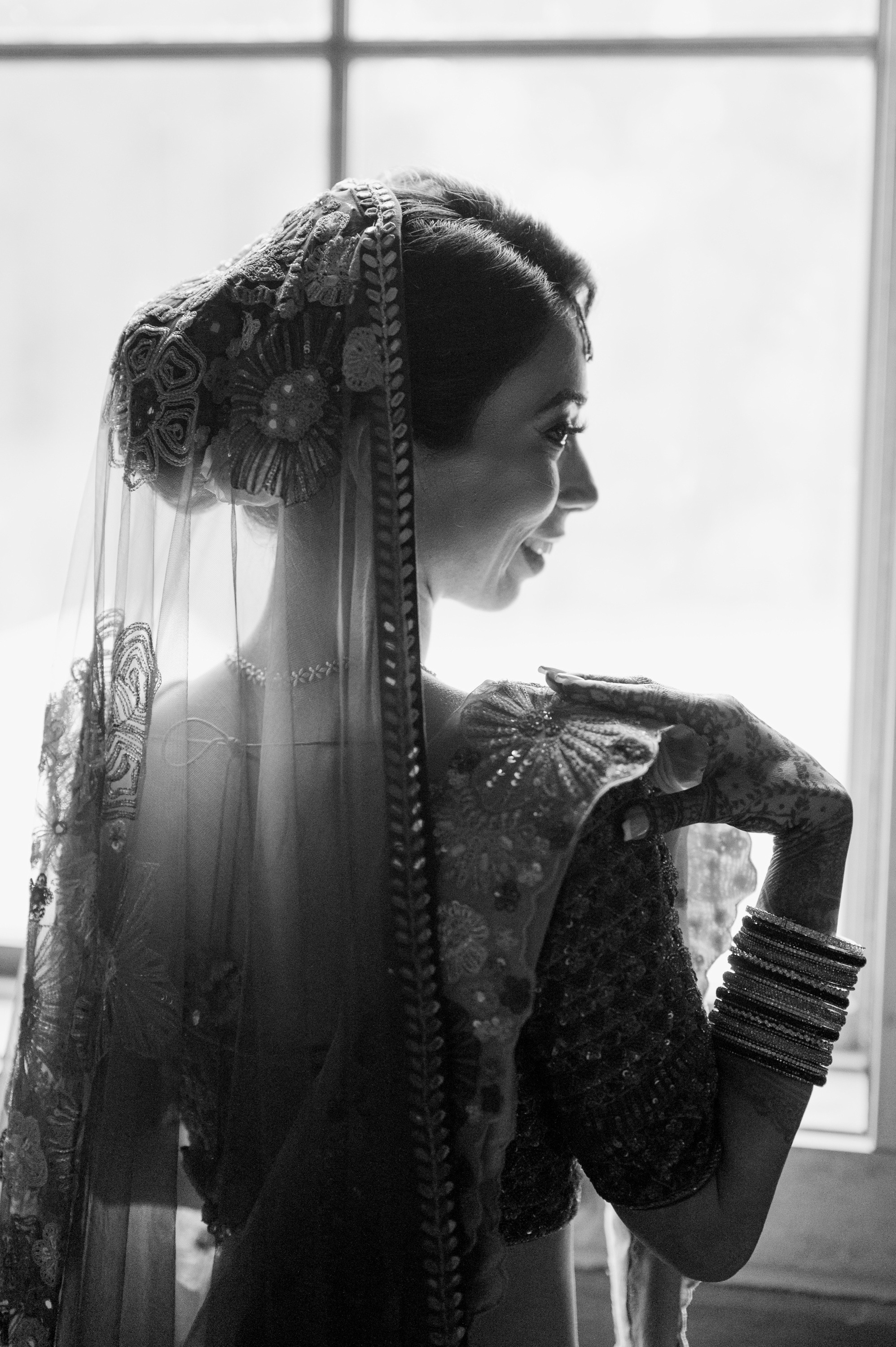 a woman in a wedding dress looking out the window