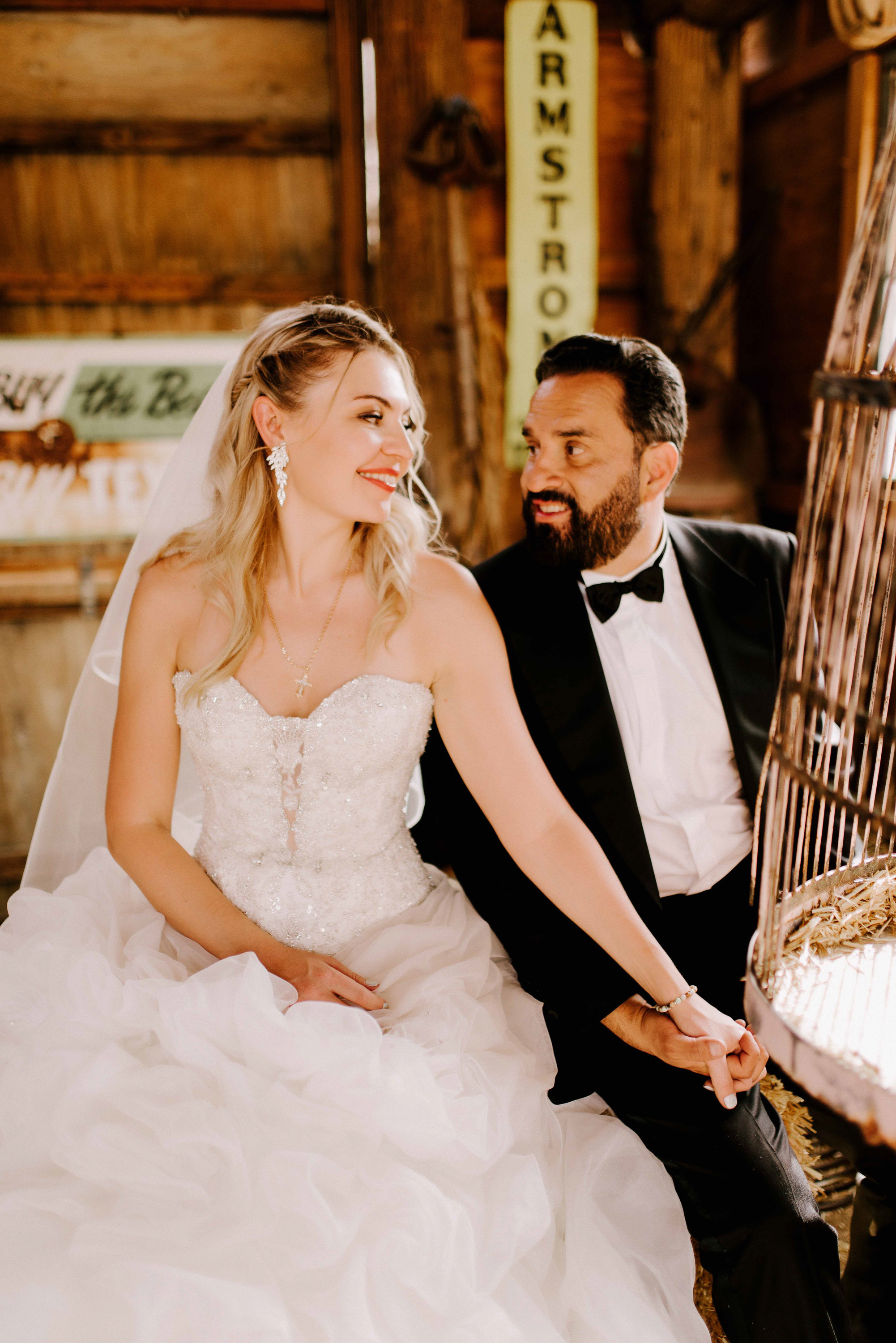 a bride and groom sitting on a bench