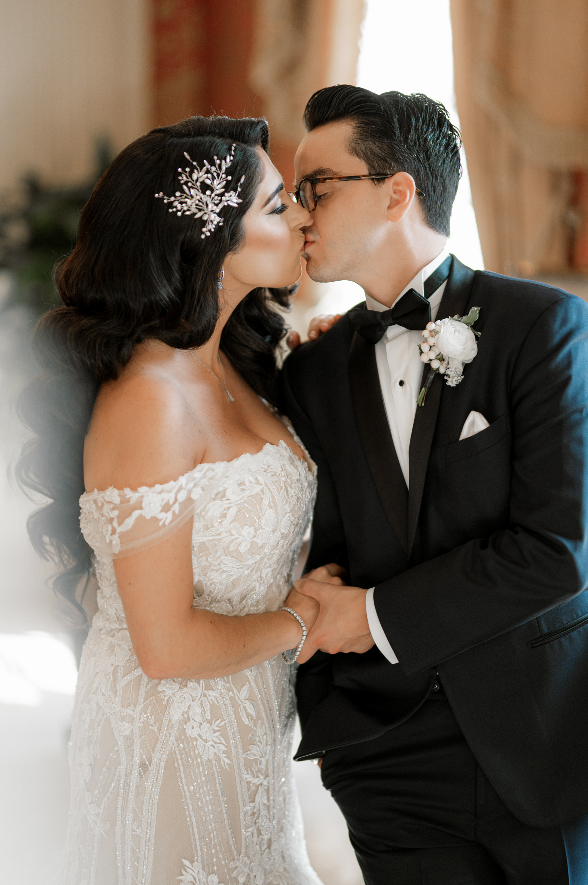 a bride and groom kissing in a room