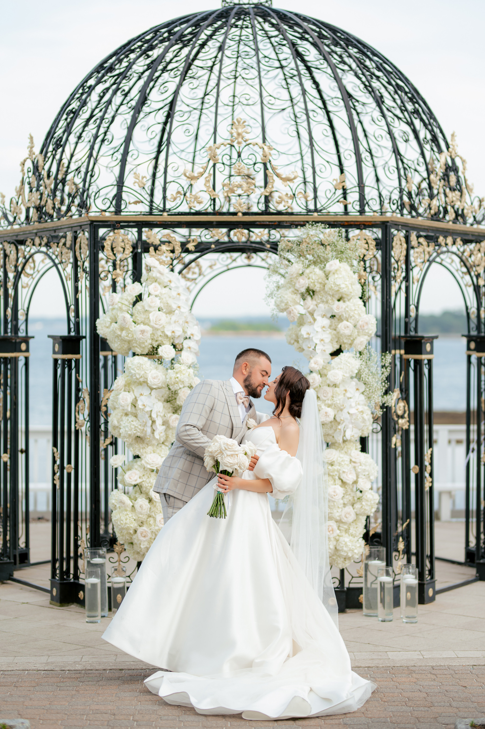 a bride and groom kissing under a gaze at their wedding