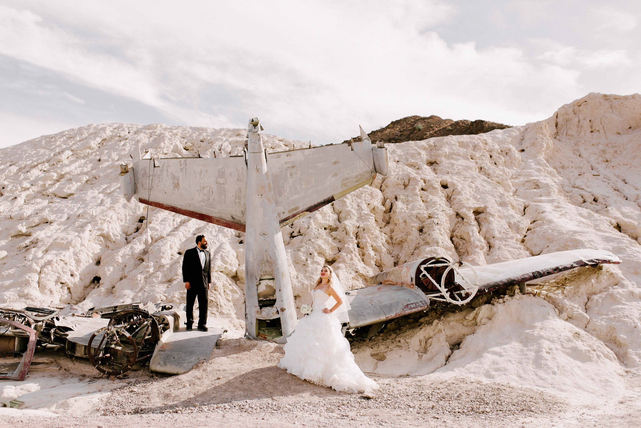 a bride and groom standing in front of a plane